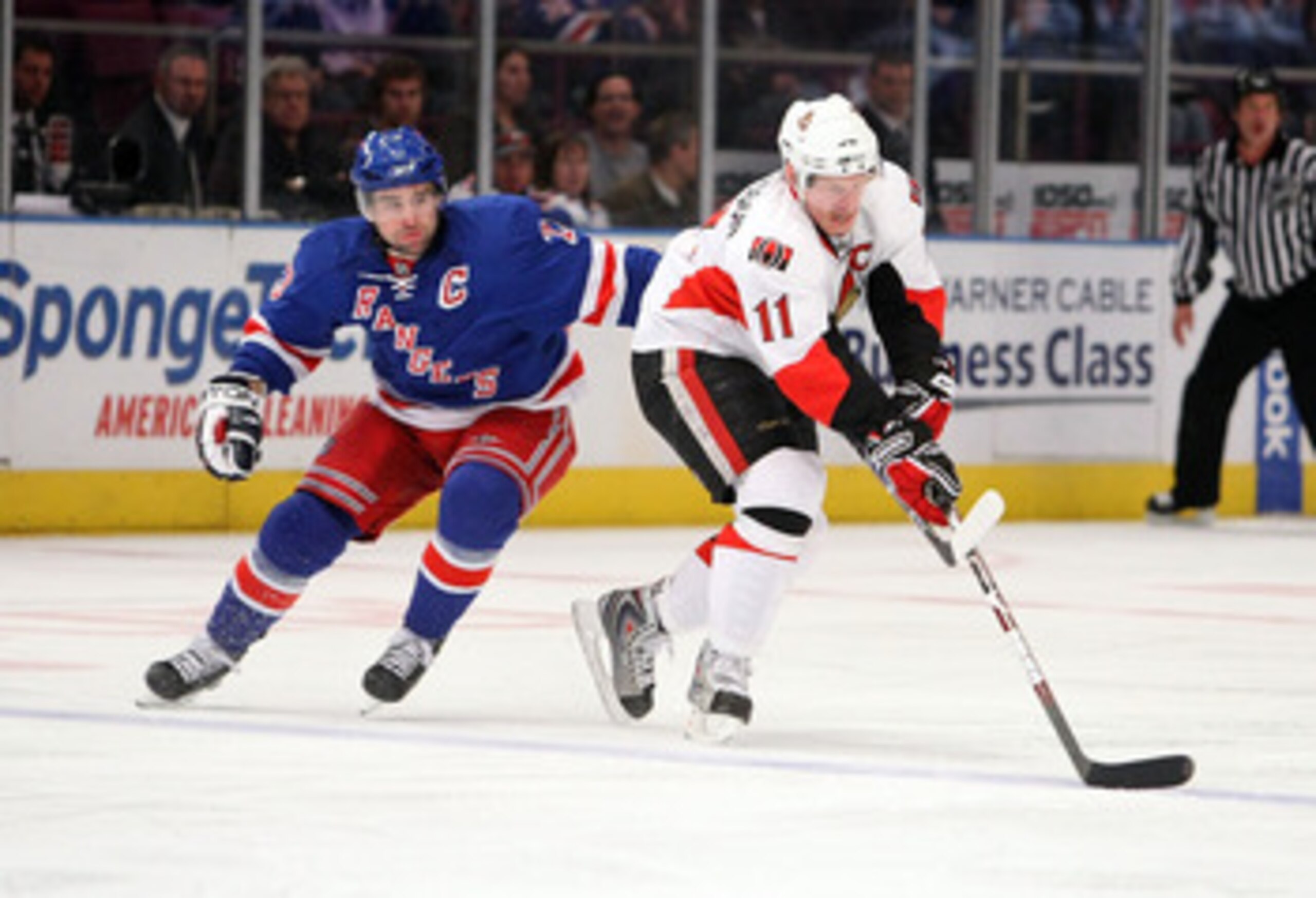 NEW YORK - MARCH 22: Daniel Alfredsson #11 of the Ottawa Senators skates with the puck in front of Chris Drury #23 of the New York Rangers on March 22, 2009 at Madison Square Garden in New York City, New York.  (Photo by Nick Laham/Getty Images)