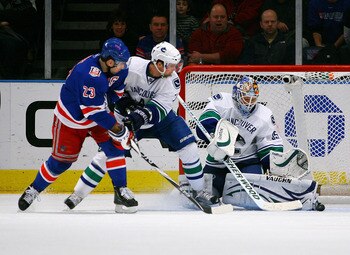 NEW YORK , NY - JANUARY 13: Goaltender Cory Schneider #35 of the Vancouver Canucks makes a skate save as Dan Hamhuis #2 checks Chris Drury #23 of the New York Rangers during the game at Madison Square Garden on January 13, 2011 in New York City. (Photo by