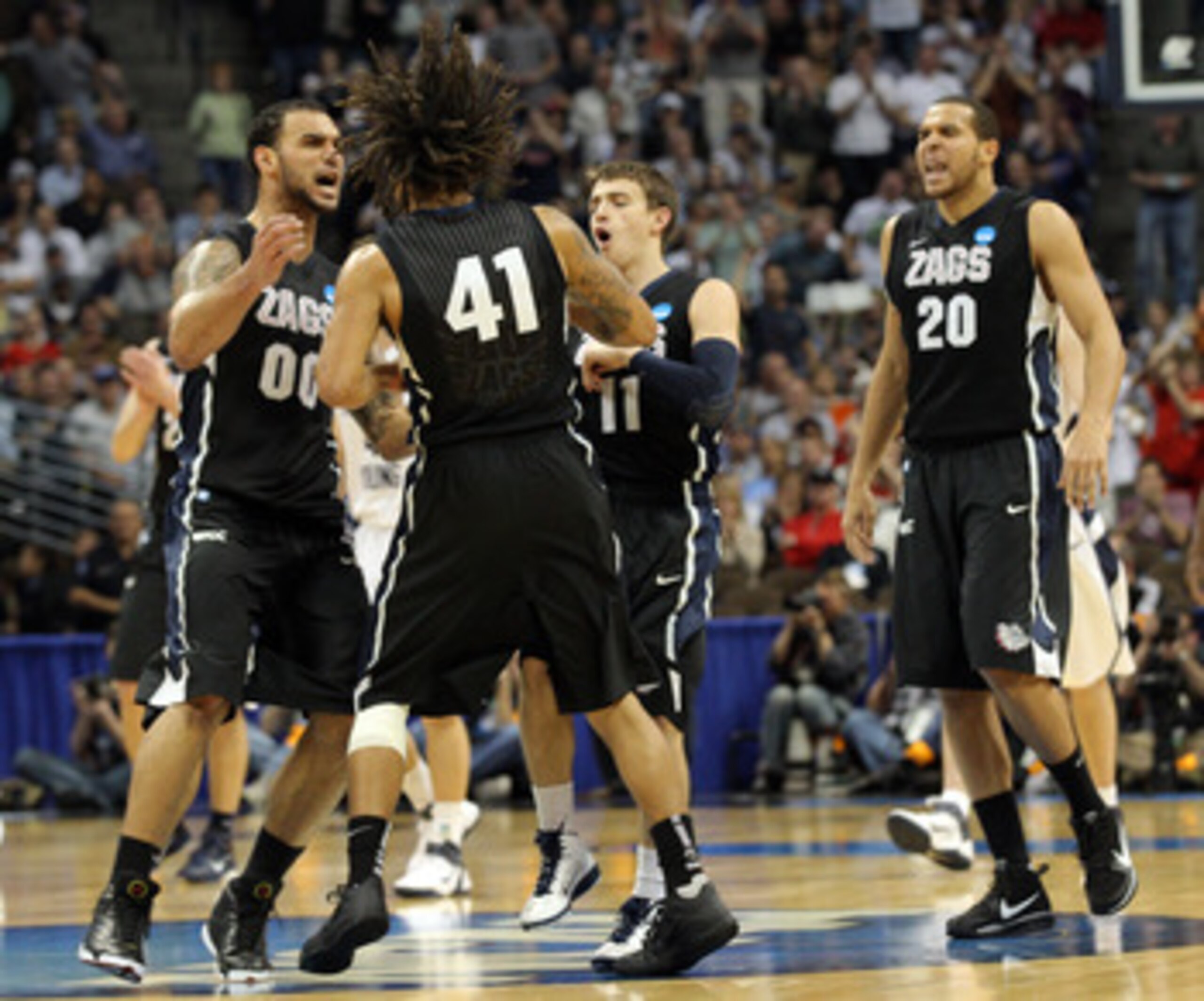 DENVER, CO - MARCH 19:  David Stockton #11, Elias Harris #20, Steven Gray #41 and Robert Sacre #00 of the Gonzaga Bulldogs celebrate after a playing against the Brigham Young Cougars during the third round of the 2011 NCAA men's basketball tournament at P