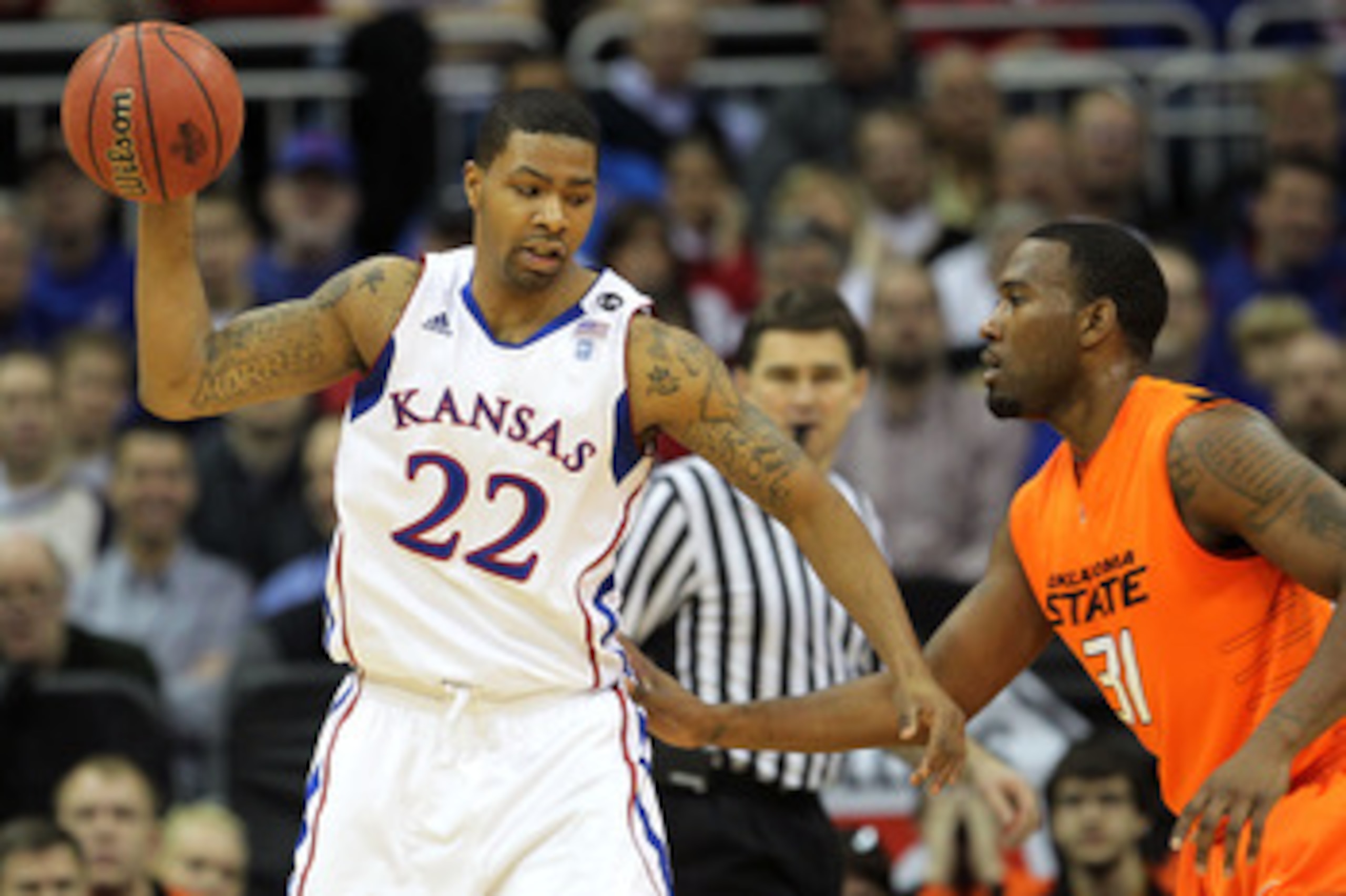 KANSAS CITY, MO - MARCH 10:  Marcus Morris #22 of the Kansas Jayhawks looks to move the ball against Matt Pilgrim #31 of the Oklahoma State Cowboys during their quarterfinal game in the 2011 Phillips 66 Big 12 Men's Basketball Tournament at Sprint Center