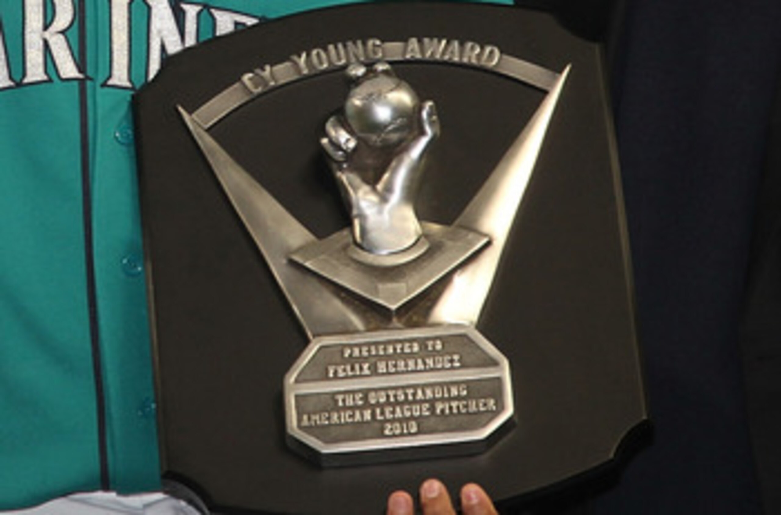 SEATTLE - APRIL 08:  Starting pitcher Felix Hernandez #34 of the Seattle Mariners is flanked by CEO Howard Lincoln (L) and COO Chuck Armstrong after receiving his American League Cy Young Award trophy prior to the Mariners' home opener against the Clevela