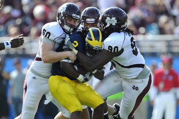 JACKSONVILLE, FL - JANUARY 01:  Chris White #50 and Pernell McPhee #90 of the Mississippi State Bulldogs tackle Vincent Smith # 2 of the Michigan Wolverines during the Gator Bowl at EverBank Field on January 1, 2011 in Jacksonville, Florida  (Photo by Ric