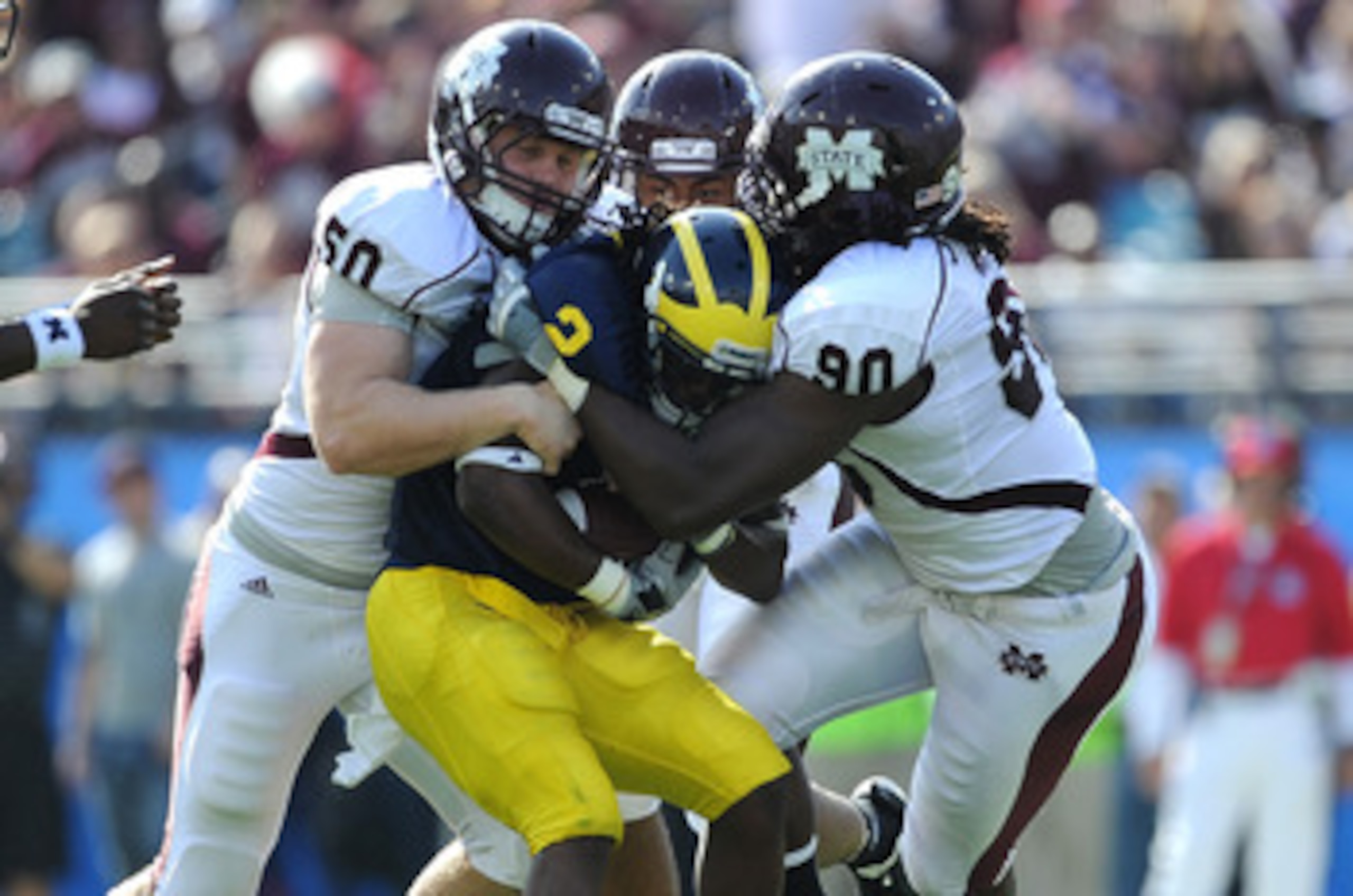JACKSONVILLE, FL - JANUARY 01:  Chris White #50 and Pernell McPhee #90 of the Mississippi State Bulldogs tackle Vincent Smith # 2 of the Michigan Wolverines during the Gator Bowl at EverBank Field on January 1, 2011 in Jacksonville, Florida  (Photo by Ric