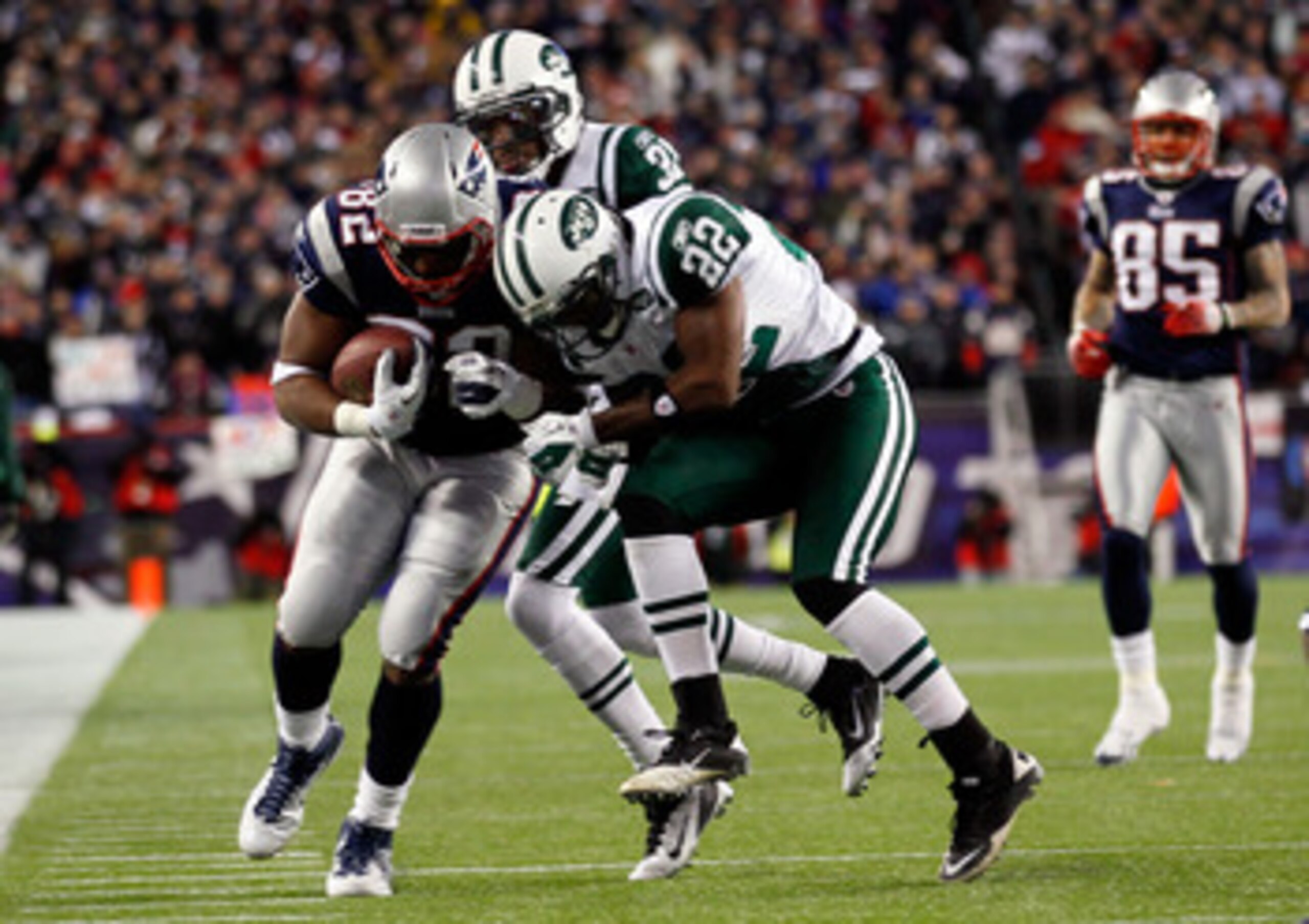 FOXBORO, MA - JANUARY 16:  Alge Crumpler #82 of the New England Patriots tries to avoid the tackle of Brodney Pool #22 of the New York Jets during their 2011 AFC divisional playoff game at Gillette Stadium on January 16, 2011 in Foxboro, Massachusetts.  (