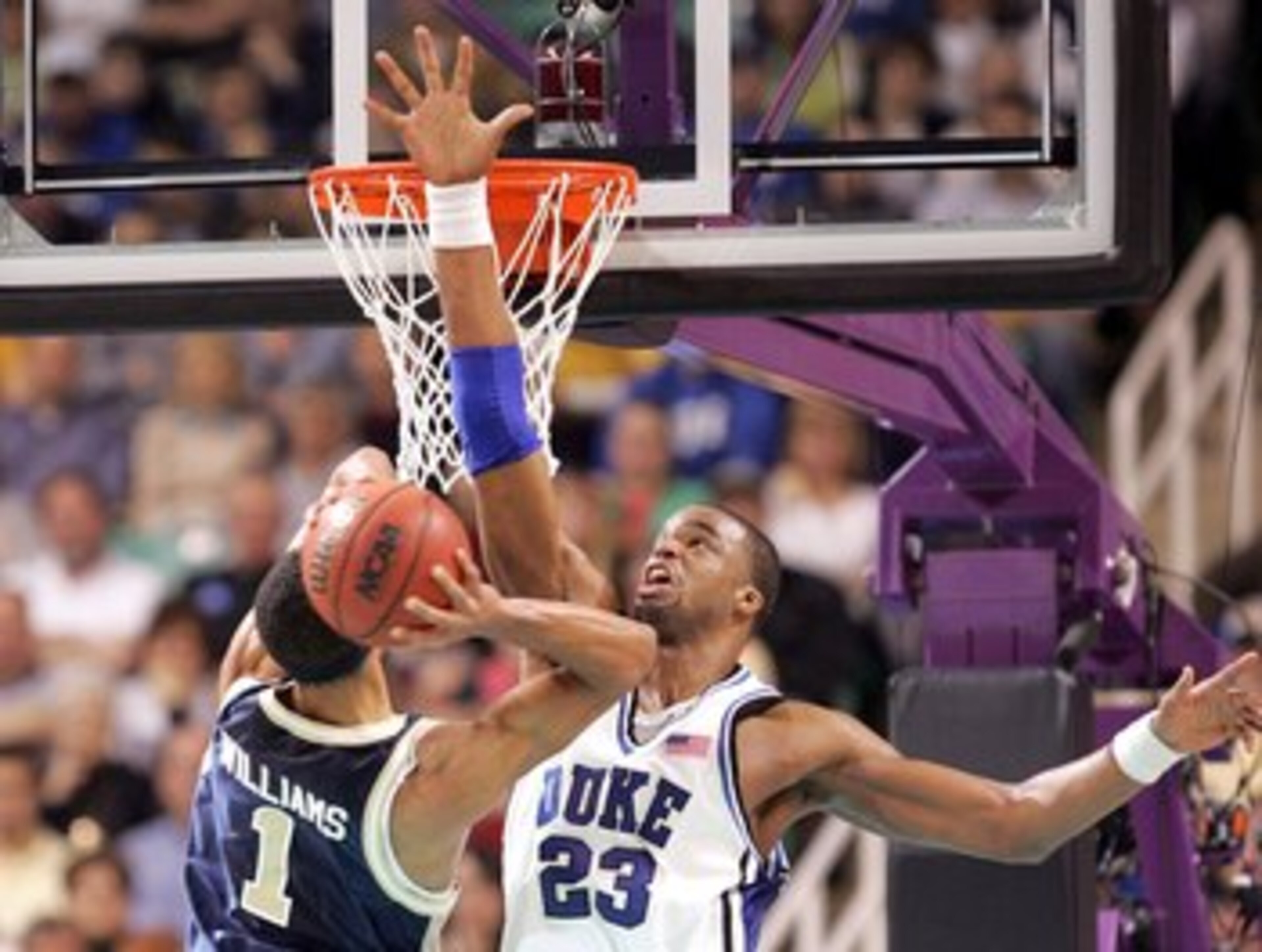 GREENSBORO, NC - MARCH 18: Shelden Williams #23 of the Duke Blue Devils tries to block Omar Williams #1 of the George Washington Colonials during the Second Round of the 2006 NCAA Men's Basketball Tournament on March 18, 2006 at the Greensboro Coliseum i GREENSBORO, NC - MARCH 18: Shelden Williams #23 of the Duke Blue Devils tries to block Omar Williams #1 of the George Washington Colonials during the Second Round of the 2006 NCAA Men's Basketball Tournament on March 18, 2006 at the Greensboro Coliseum i