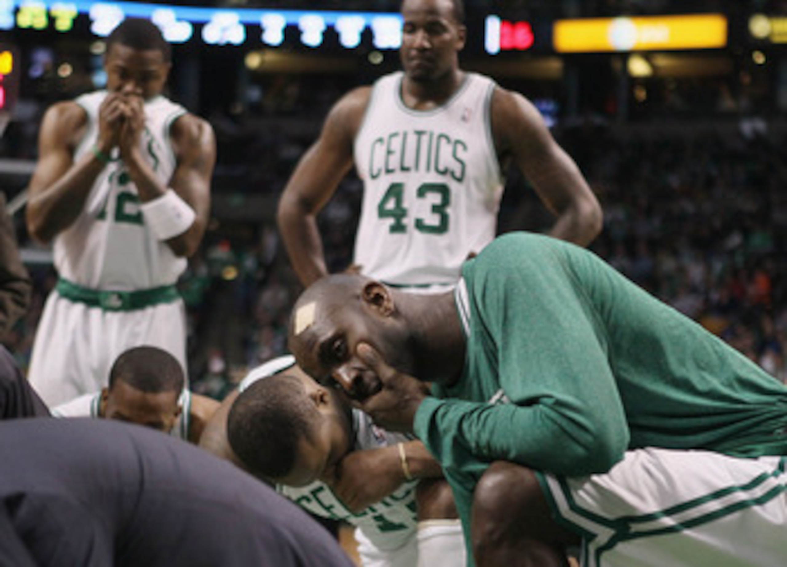BOSTON, MA - FEBRUARY 06: Kevin Garnett #5,Glen Davis #11,Kendrick Perkins #43 and Von Wafter #12 of the Boston Celtics watch as medical personnel tend to Marquis Daniels of the Celtics after Daniels collided with Gilbert Arenas of the Orlando Magic on Fe BOSTON, MA - FEBRUARY 06: Kevin Garnett #5,Glen Davis #11,Kendrick Perkins #43 and Von Wafter #12 of the Boston Celtics watch as medical personnel tend to Marquis Daniels of the Celtics after Daniels collided with Gilbert Arenas of the Orlando Magic on Fe