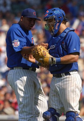 CHICAGO - JULY 2:  Carlos Zambrano #38 of the Chicago Cubs gets assistance from teammate Michael Barrett #5 after getting a cramp in his right forearm during a game against the Chicago White Sox on July 2, 2004 at Wrigley Field in Chicago, Illinois. The C
