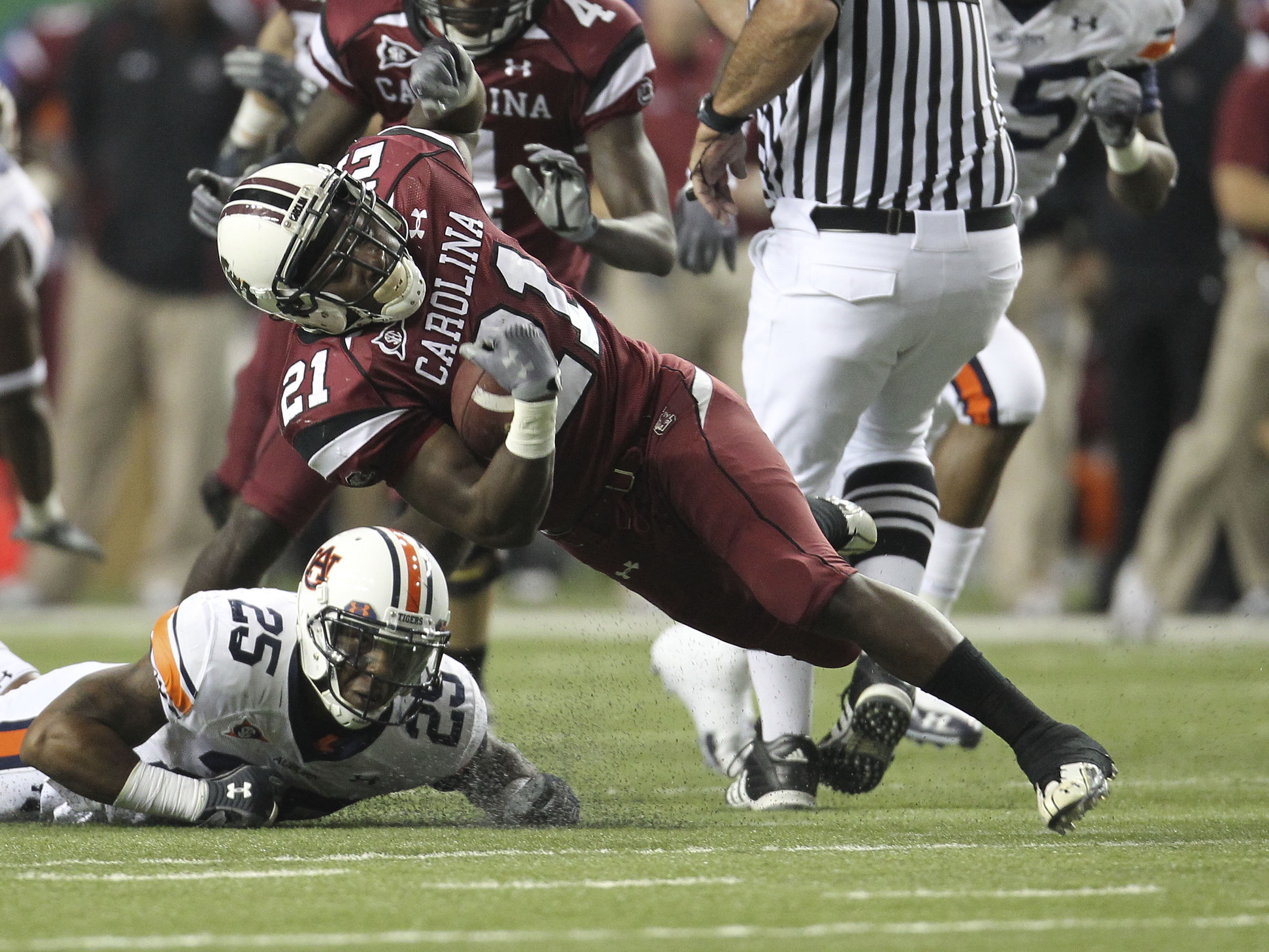ATLANTA - DECEMBER 4:  Running back Marcus Lattimore #21 of the South Carolina Gamecocks is tackled by Daren Bates #25 of the Auburn Tigers during the 2010 SEC Championship at Georgia Dome on December 4, 2010 in Atlanta, Georgia. (Photo by Mike Zarrilli/G