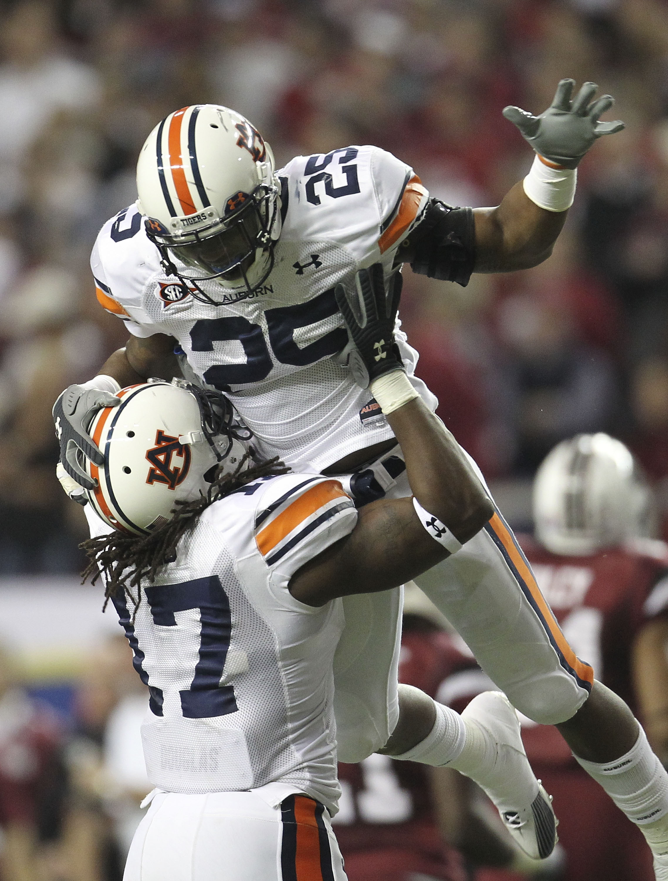 ATLANTA - DECEMBER 4:  Linebacker Daren Bates #25 of the Auburn Tigers is hoisted by teammate and linebacker Josh Bynes #17 after Bates' interception during the 2010 SEC Championship against the South Carolina Gamecocks at Georgia Dome on December 4, 2010