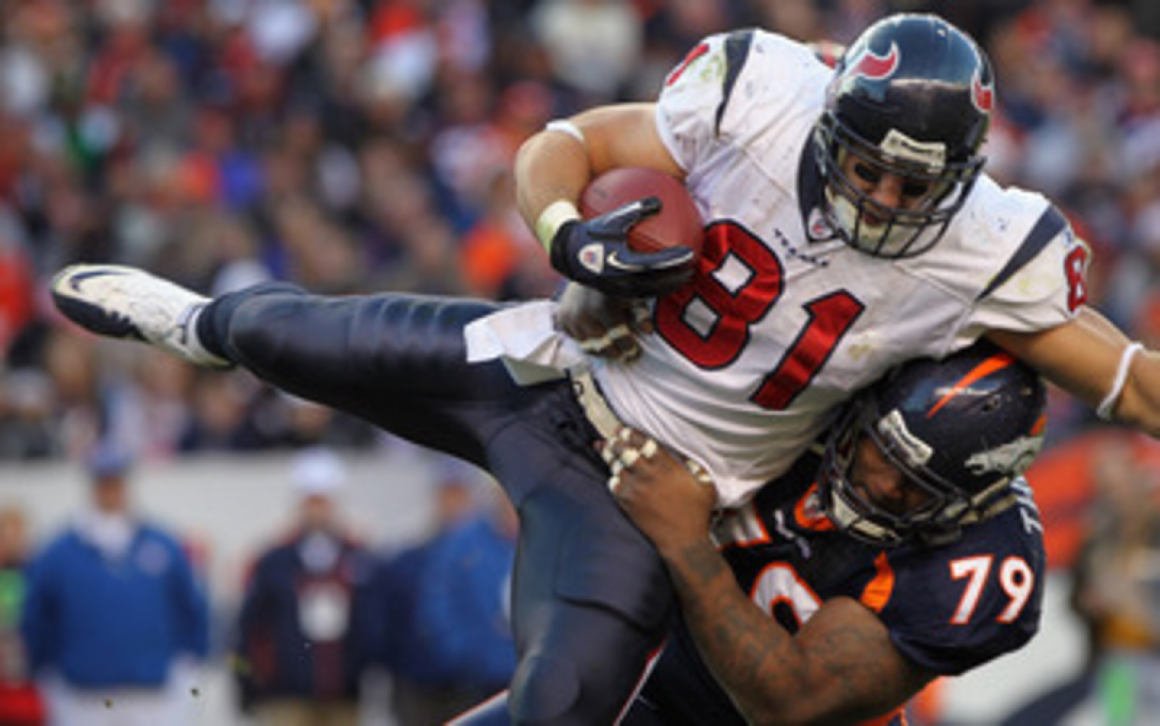 DENVER - DECEMBER 26:  Wide receiver Owen Daniels #81 of the Houston Texas makes a reception and is tackled by defensive lineman Marcus Thomas #79 of the Denver Broncos at INVESCO Field at Mile High on December 26, 2010 in Denver, Colorado. The Broncos de