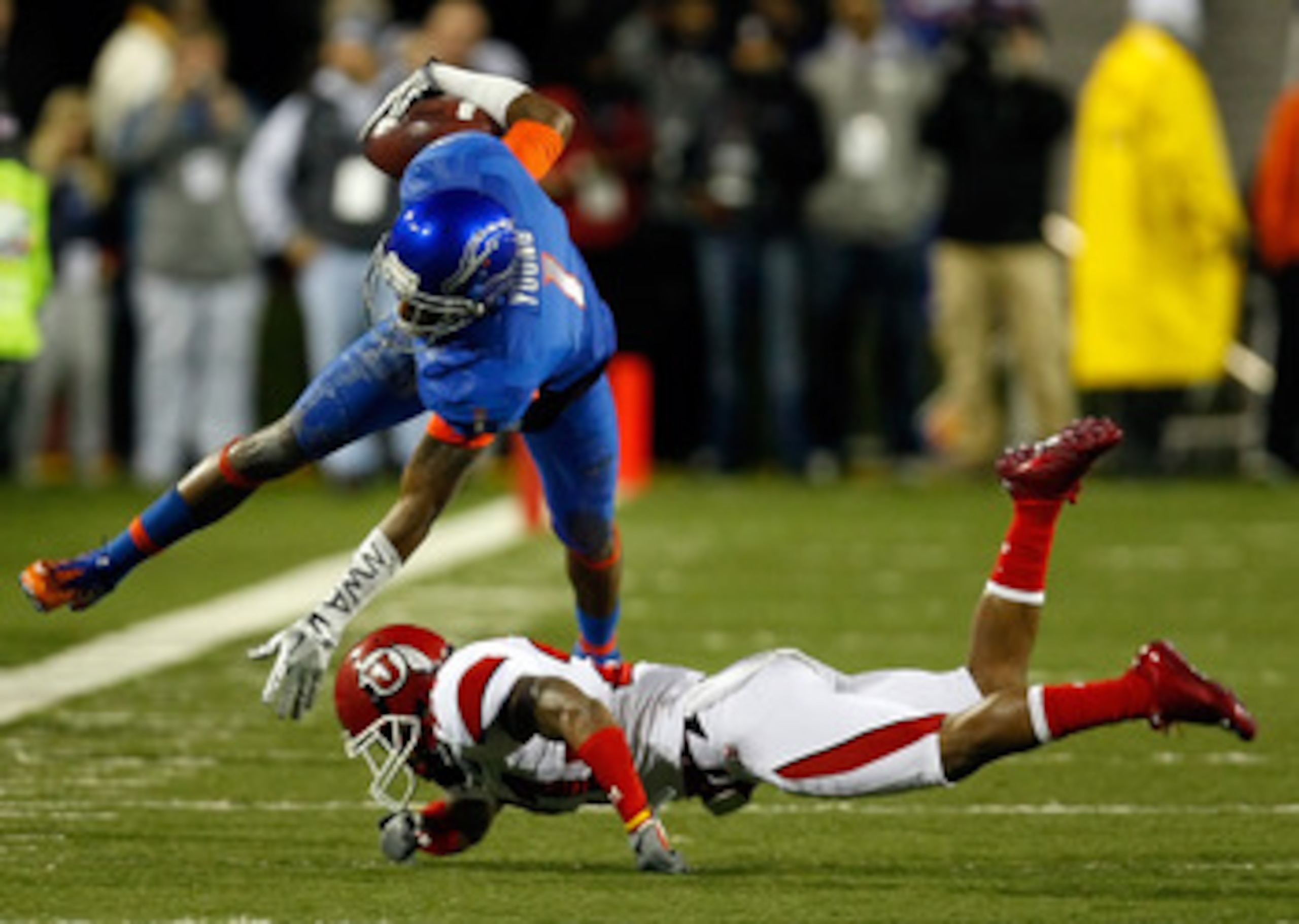 LAS VEGAS, NV - DECEMBER 22:  Titus Young #1 of the Boise State Broncos is tripped up by Brian Blechen #2 of the Utah Utes during the MAACO Bowl Las Vegas at Sam Boyd Stadium December 22, 2010 in Las Vegas, Nevada.  (Photo by Ethan Miller/Getty Images)