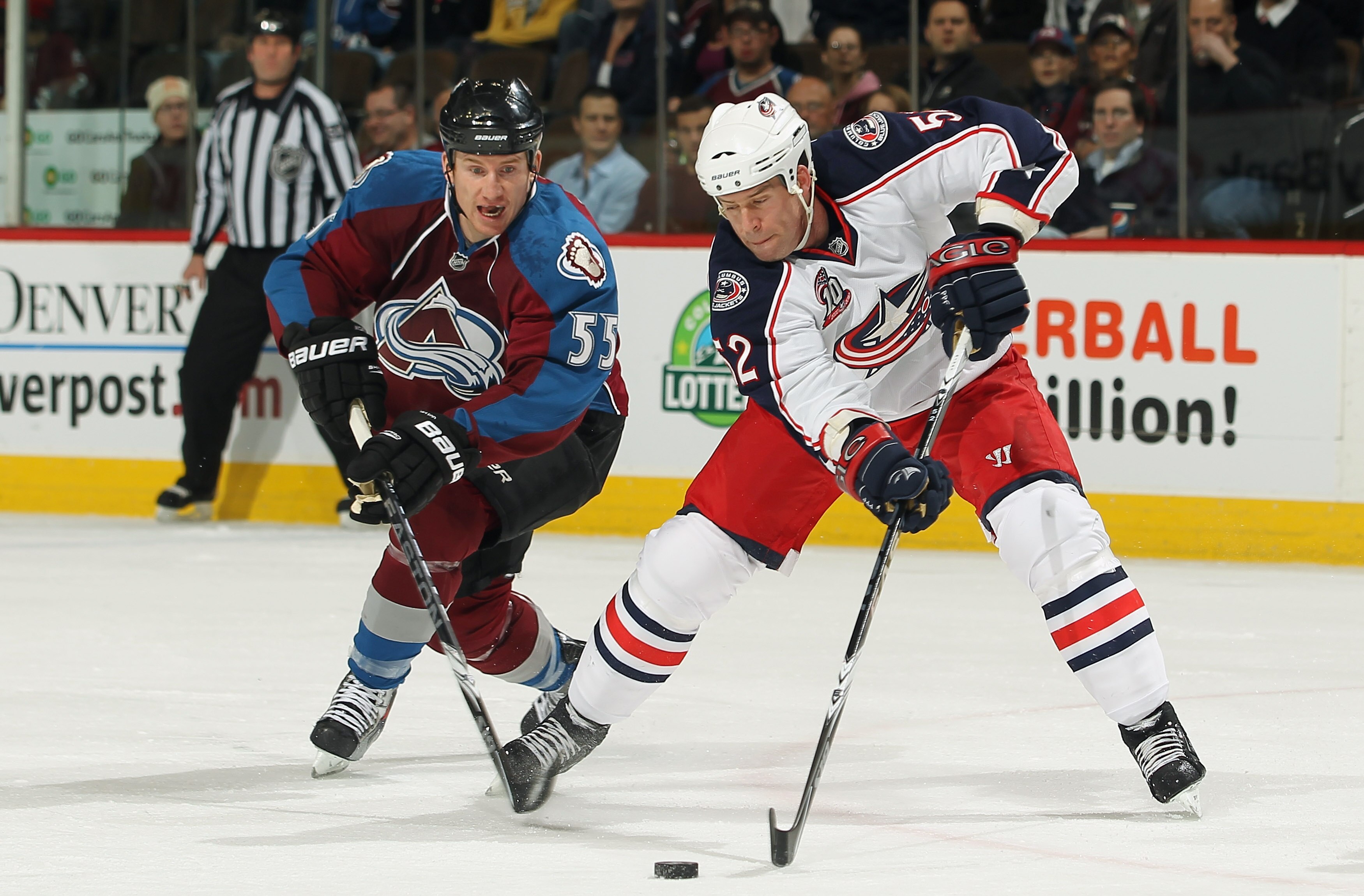 DENVER, CO - MARCH 22:  Craig Rivet #52 of the Columbus Blue Jackets controls the puck while under pressure from Cody McLeod #55 of the Colorado Avalanche at the Pepsi Center on March 22, 2011 in Denver, Colorado.  (Photo by Doug Pensinger/Getty Images)