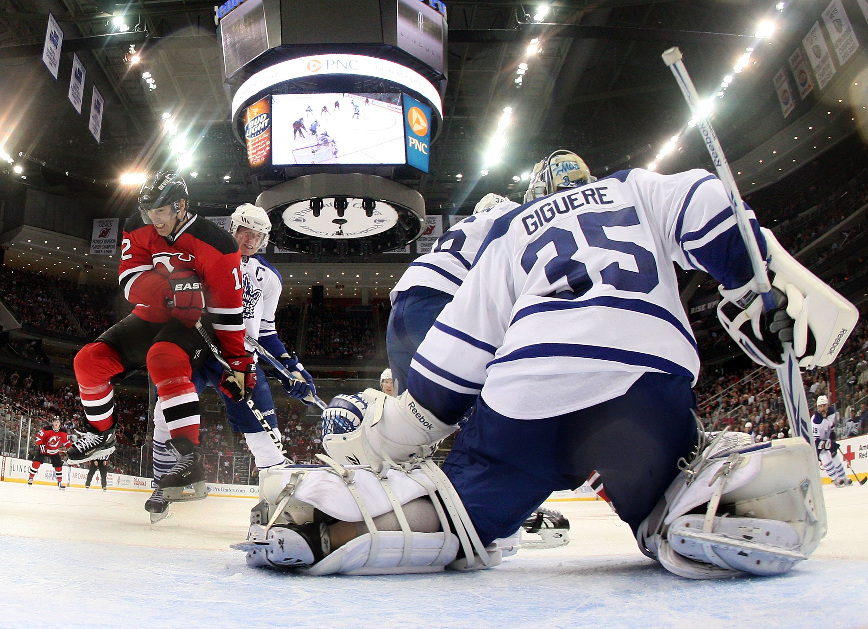 NEWARK, NJ - APRIL 06: Jean-Sebastien Giguere #35 of the Toronto Maple Leafs blocks the net as Brian Rolston #12 of the New Jersey Devils takes a hit at the Prudential Center on April 6, 2011 in Newark, New Jersey. The Devils defeated the Maple Leafs 4-2.