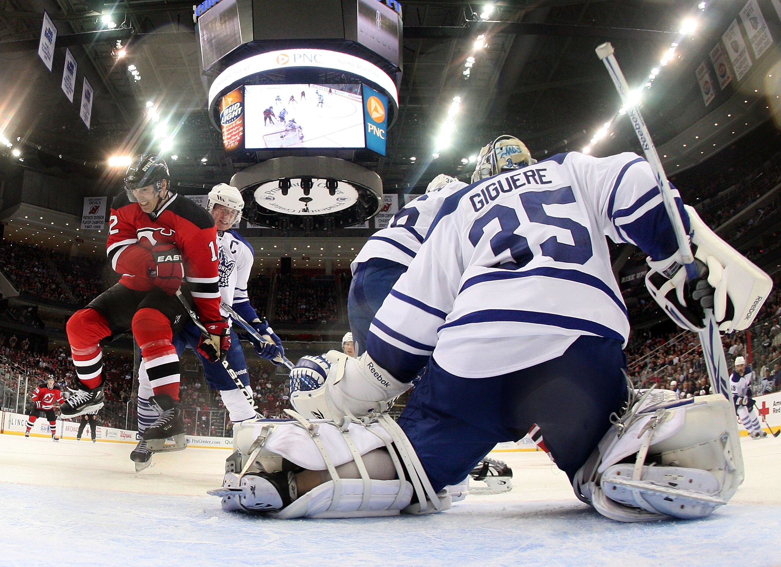 NEWARK, NJ - APRIL 06: Jean-Sebastien Giguere #35 of the Toronto Maple Leafs blocks the net as Brian Rolston #12 of the New Jersey Devils takes a hit at the Prudential Center on April 6, 2011 in Newark, New Jersey. The Devils defeated the Maple Leafs 4-2.