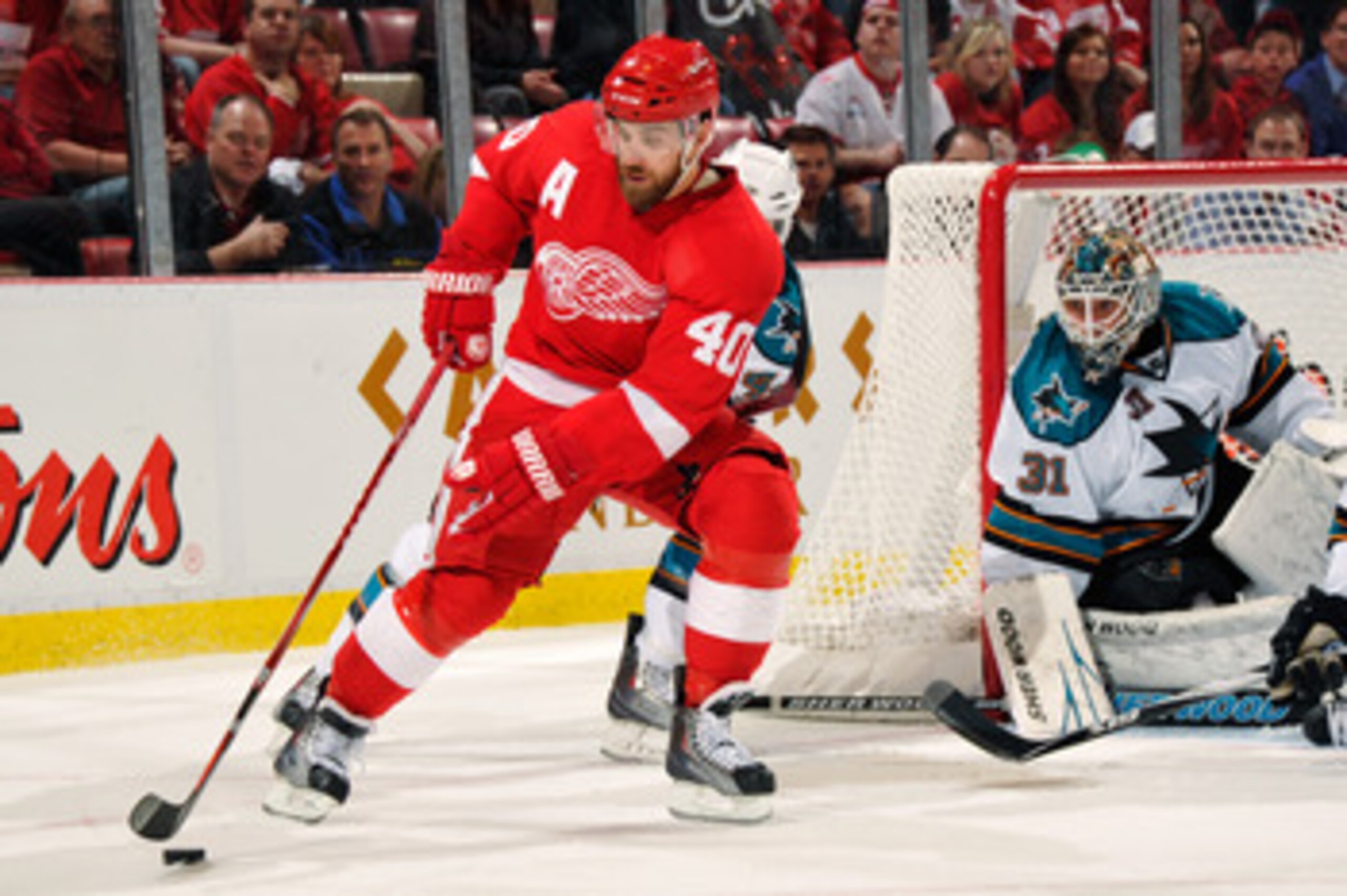 DETROIT - MAY 4:  Henrik Zetterberg #40 of the Detroit Red Wings controls the puck in front of goaltender Antti Niemi #31 of the San Jose Sharks in Game Three of the Western Conference Semifinals during the 2011 NHL Stanley Cup Playoffs on May 4, 2011 at