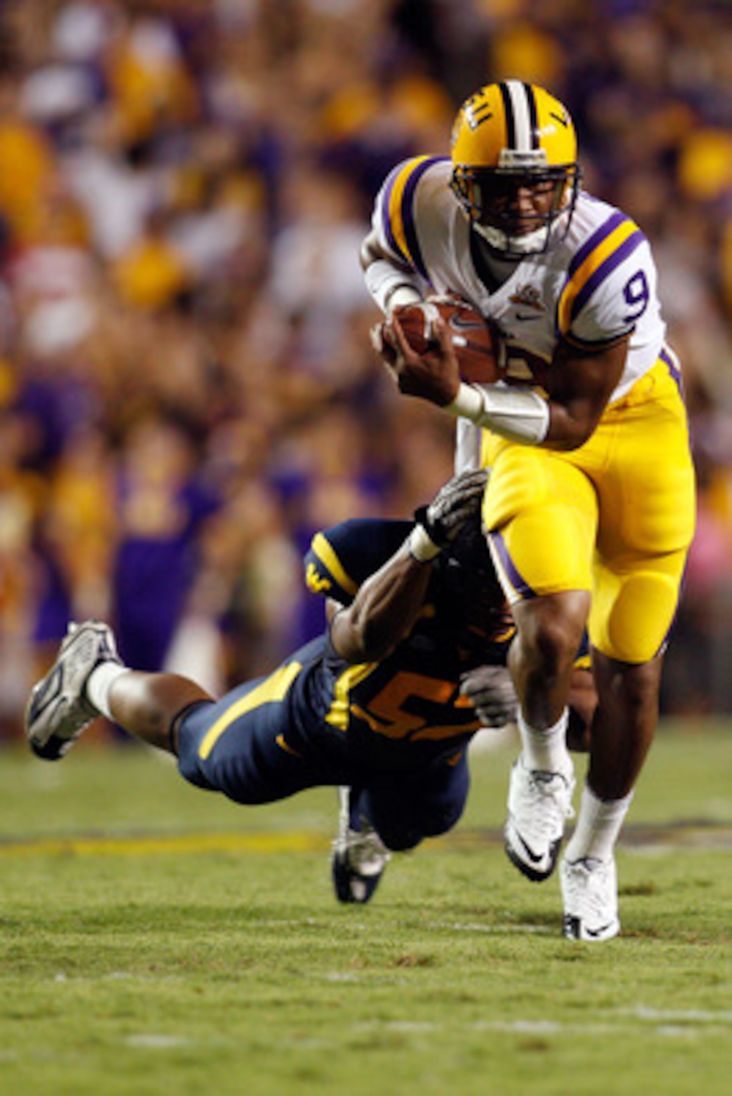 BATON ROUGE, LA - SEPTEMBER 25:  Jordan Jefferson #9 of the Louisiana State Univeristy Tigers avoids a tackle by Najee Goode #52 of the West Virginia Mountaineers at Tiger Stadium on September 25, 2010 in Baton Rouge, Louisiana.  (Photo by Chris Graythen/