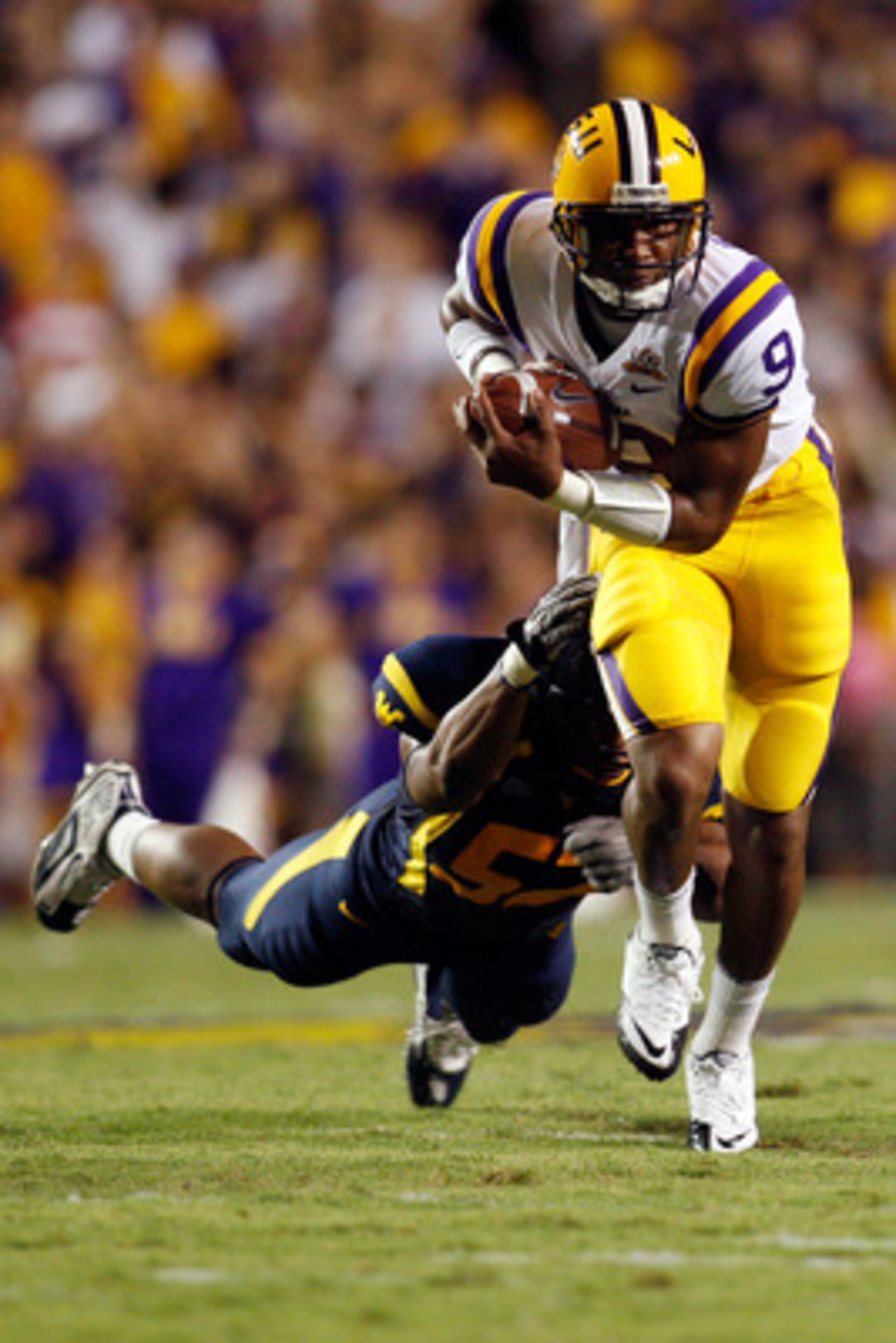 BATON ROUGE, LA - SEPTEMBER 25:  Jordan Jefferson #9 of the Louisiana State Univeristy Tigers avoids a tackle by Najee Goode #52 of the West Virginia Mountaineers at Tiger Stadium on September 25, 2010 in Baton Rouge, Louisiana.  (Photo by Chris Graythen/