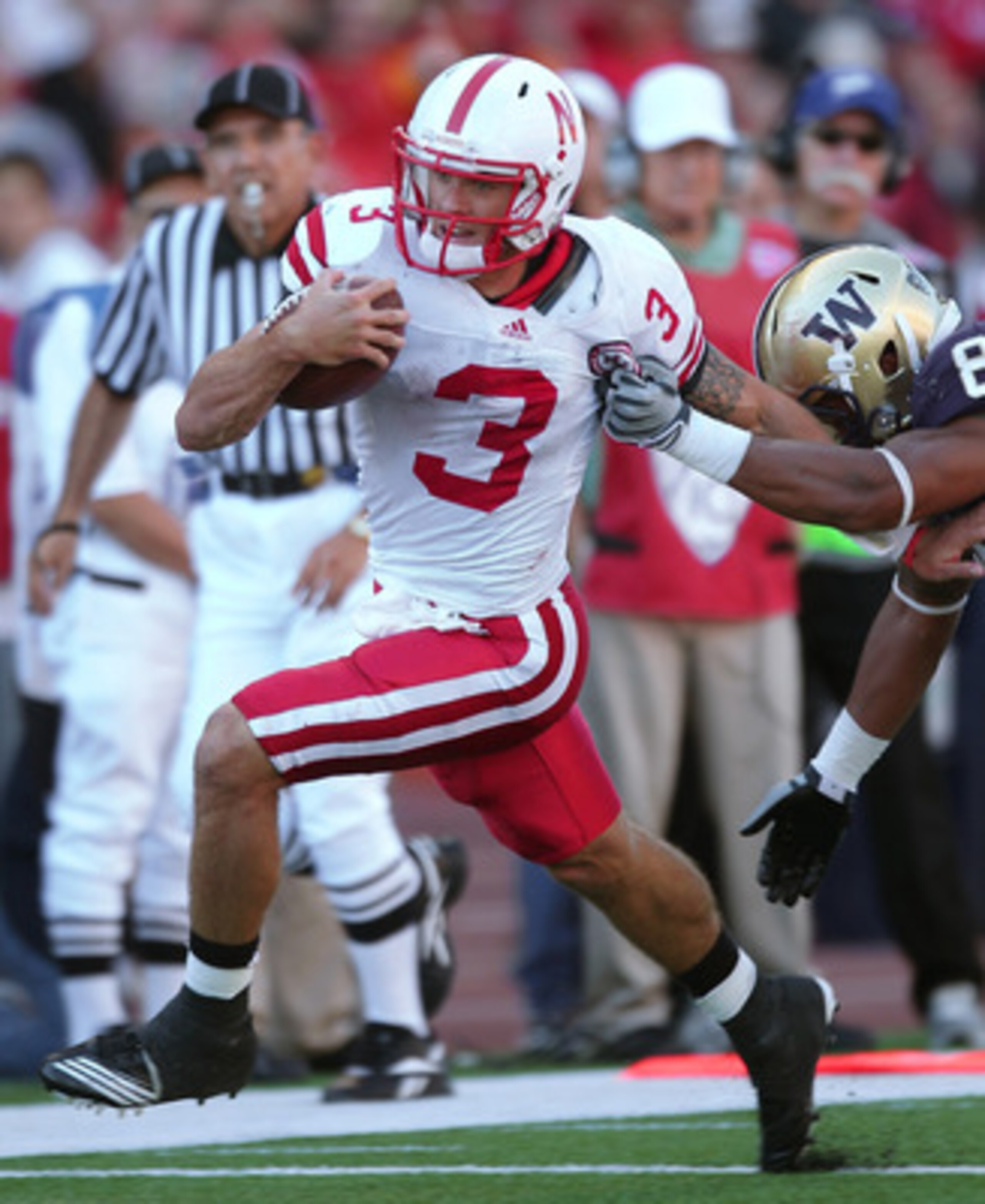 SEATTLE - SEPTEMBER 18:  Quarterback Taylor Martinez #3 of the Nebraska Cornhuskers rushes against Nate Williams #8 of the Washington Huskies on September 18, 2010 at Husky Stadium in Seattle, Washington. The Cornhuskers defeated the Huskies 56-21. (Photo