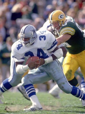 GREEN BAY, WI - OCTOBER 8:  Running back Herschel Walker #34 of the Dallas Cowboys makes a cut up field to avoid the pursuing defense of the Green Bay Packers during the Cowboys 31-13 loss to the Packers on October 8, 1989 at Lambeau Field in Green Bay, W