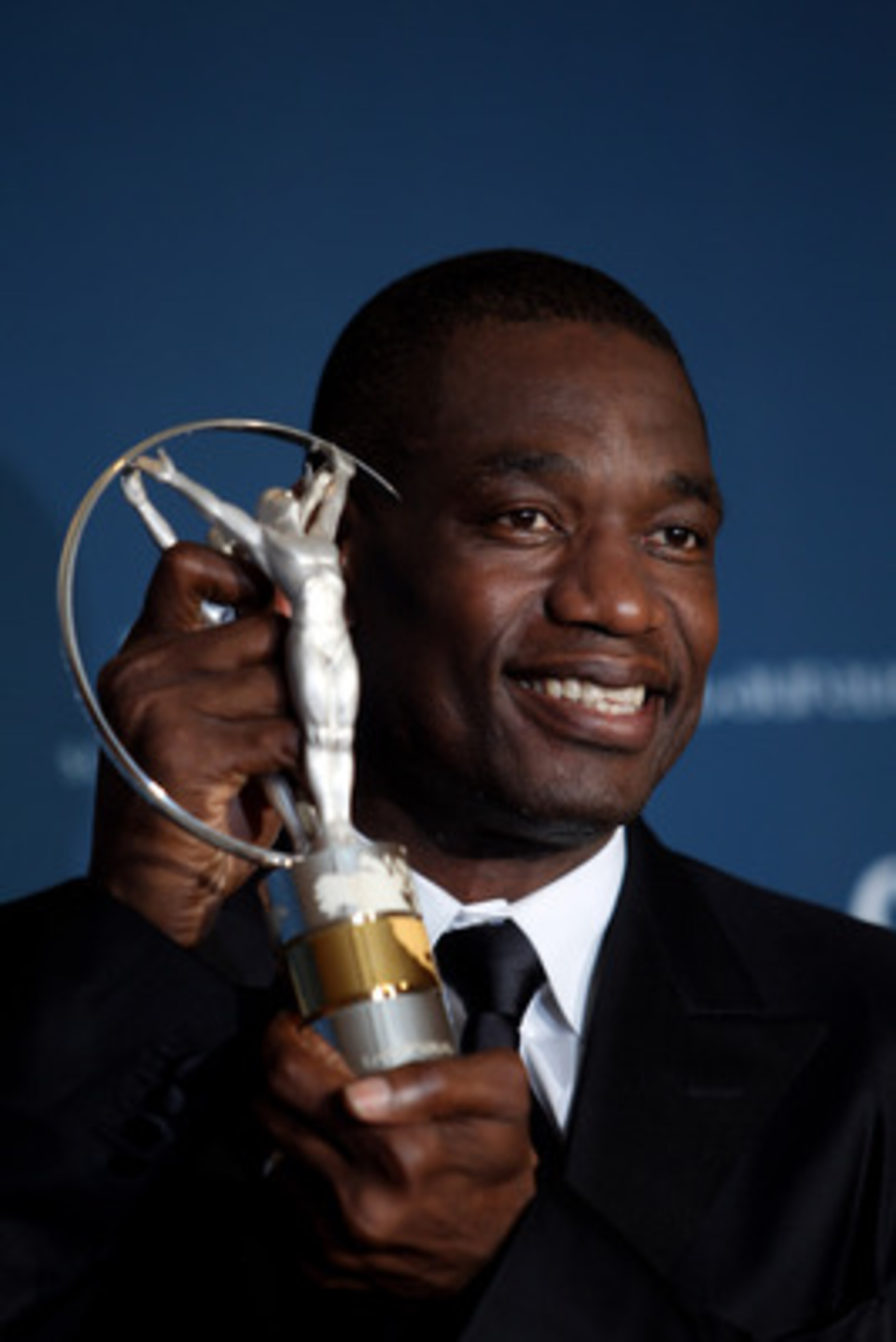 ABU DHABI, UNITED ARAB EMIRATES - MARCH 10: US basketball legend Dikembe Mutombo poses with his award for 'Sport For Good ' in the Awards room during the Laureus World Sports Awards 2010 at Emirates Palace Hotel on March 10, 2010 in Abu Dhabi, United Ar ABU DHABI, UNITED ARAB EMIRATES - MARCH 10: US basketball legend Dikembe Mutombo poses with his award for 'Sport For Good ' in the Awards room during the Laureus World Sports Awards 2010 at Emirates Palace Hotel on March 10, 2010 in Abu Dhabi, United Ar