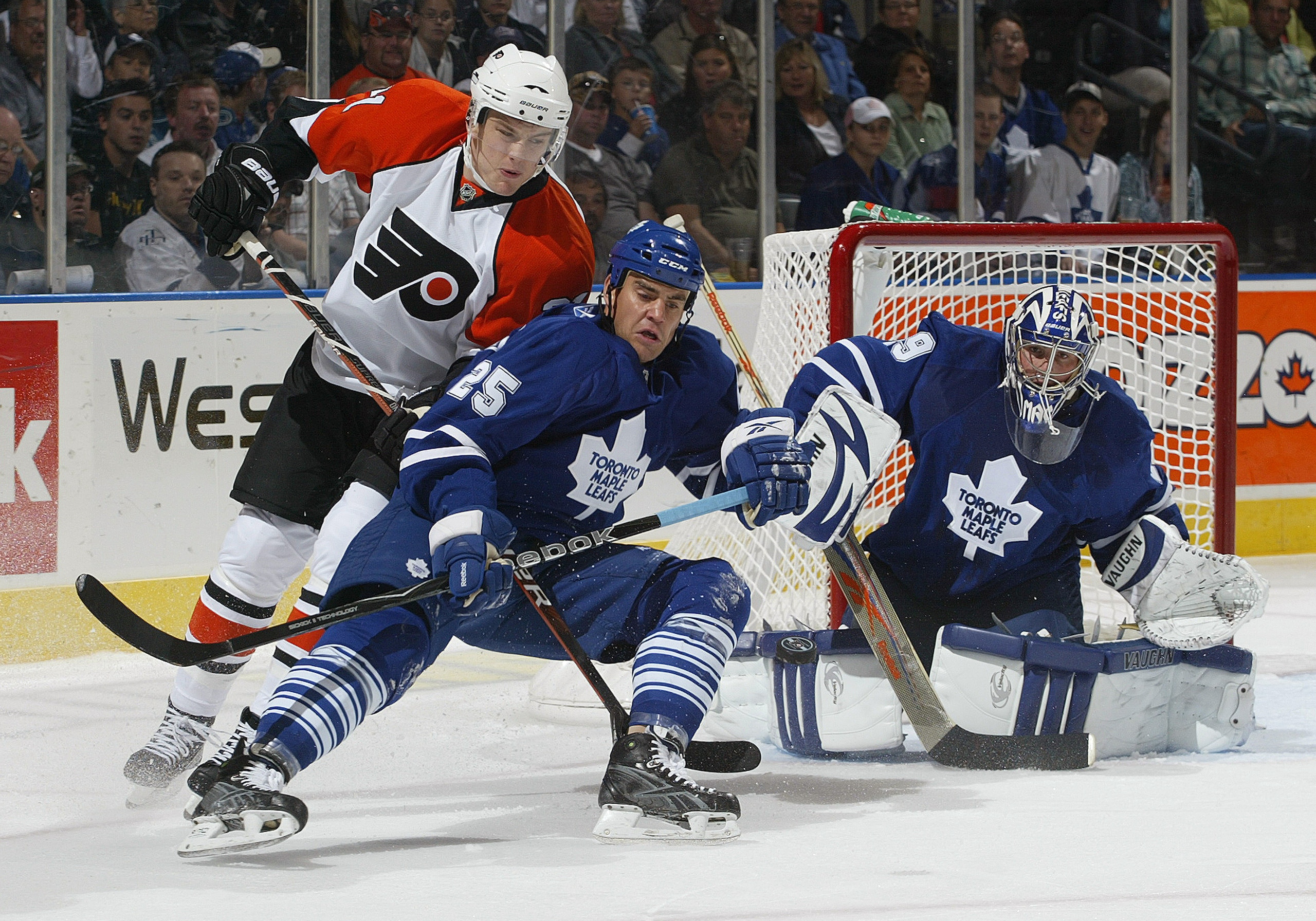 LONDON, ON - SEPTEMBER 17:  Ben Ondrus #25 and Joey MacDonald  #29 of the Toronto Maple Leafs watch an incoming shot while Ondrus tries to hold up James Van Reimsdyk #21 of the Philadelphia Flyers in a pre-season game  on September 17, 2009 at the John La