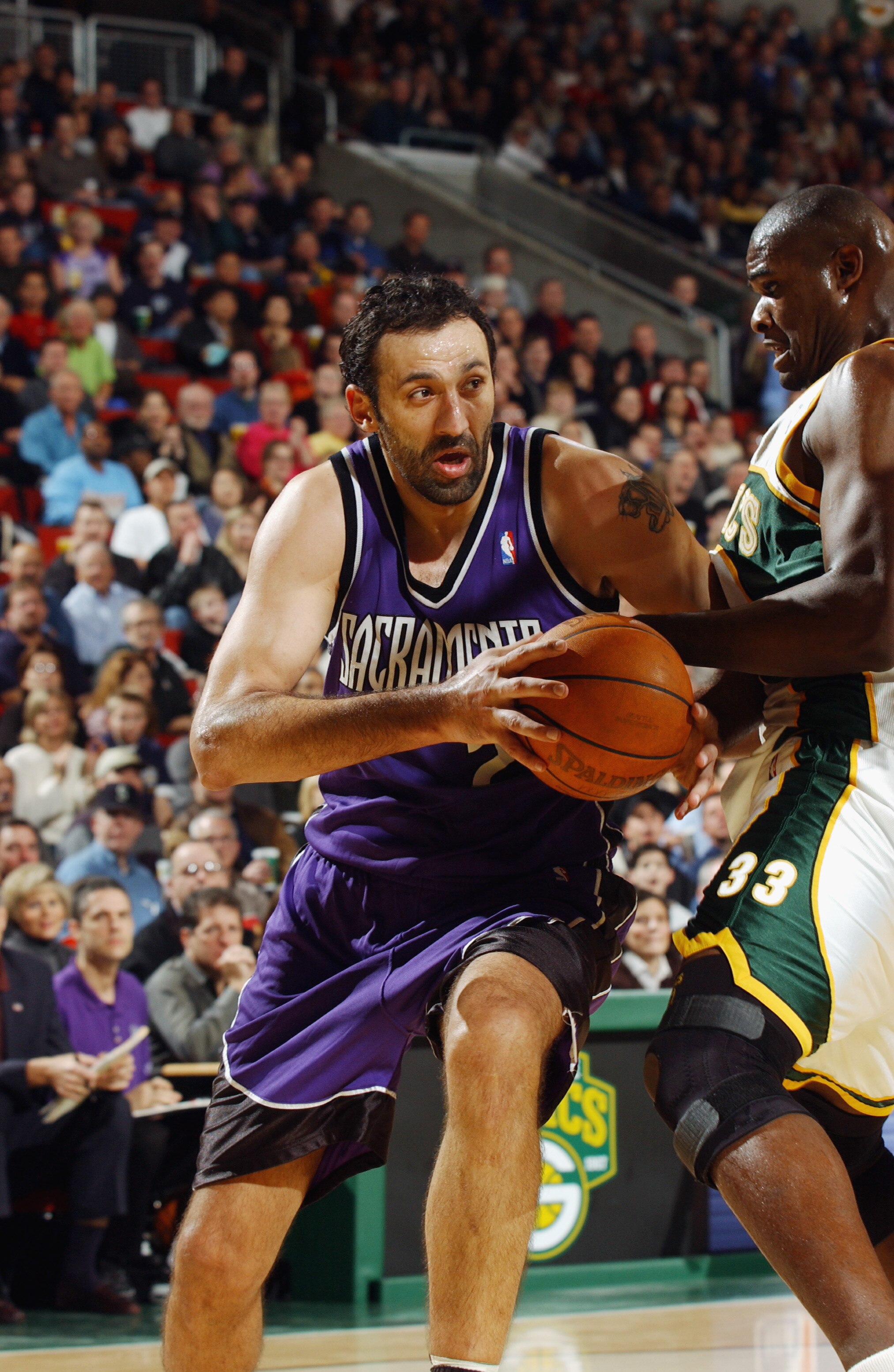SEATTLE - JANUARY 30:  Vlade Divac #21 of the Sacramento Kings goes around Jerome James #33 of the Seattle Sonics during the game at Key Arena on January 30, 2003 in Seattle, Washington.  The Kings won 95-77.  NOTE TO USER: User expressly acknowledges and
