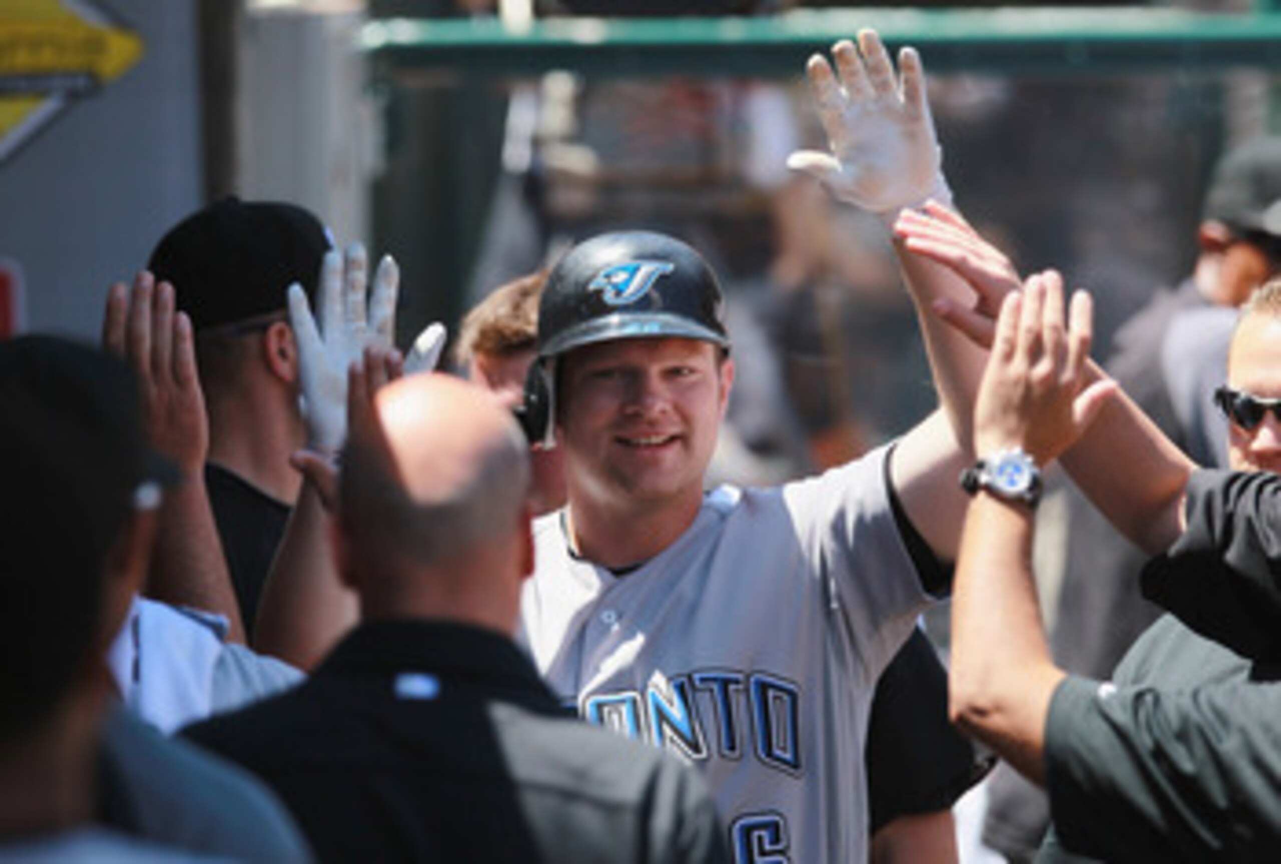 ANAHEIM, CA - AUGUST 15:  Adam Lind #26 of the Toronto Blue Jays receives high fives in the dugout after hitting a solo home run in the second inning against the Los Angeles Angels of Anaheim at Angel Stadium on August 15, 2010 in Anaheim, California.  (P