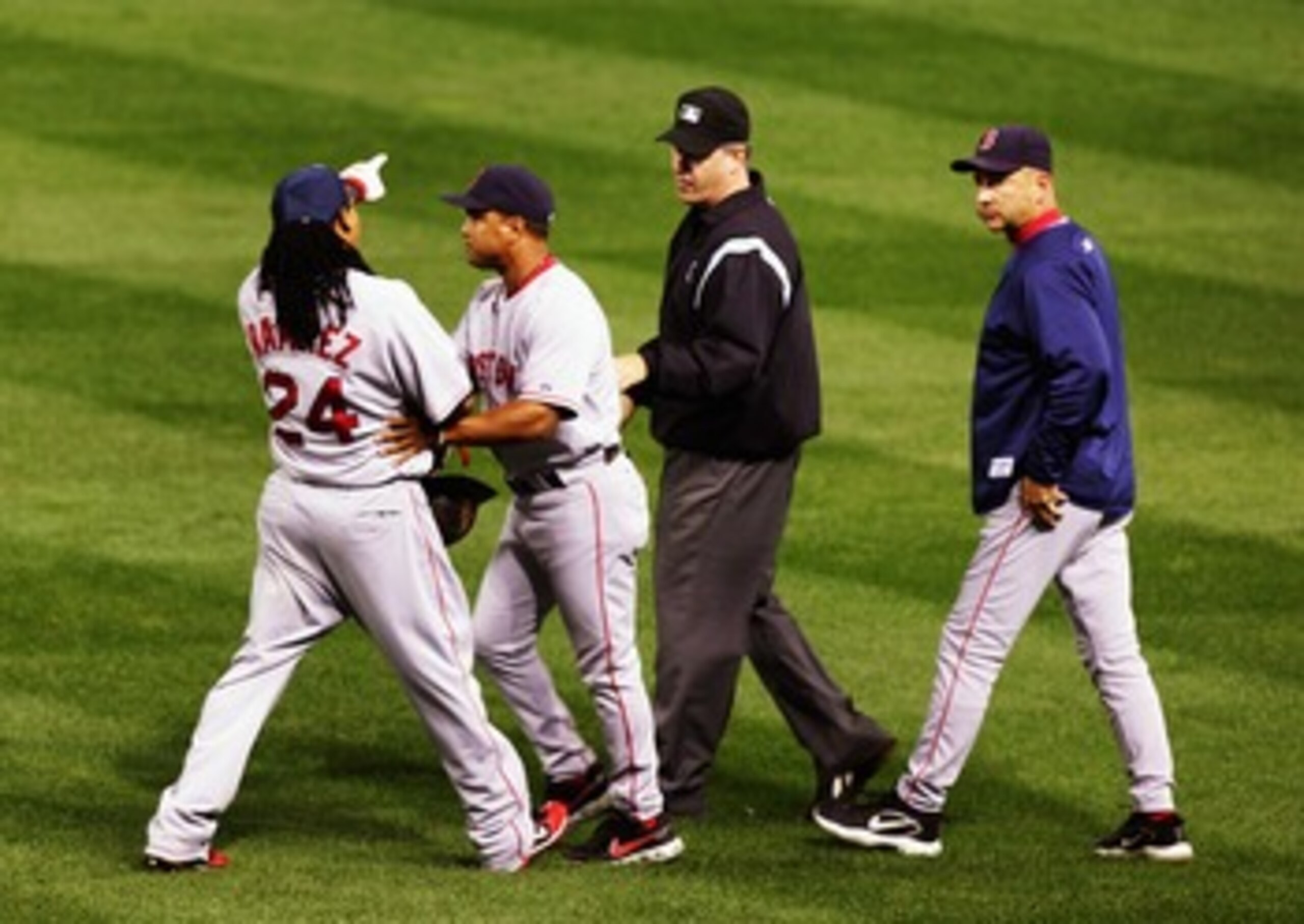 CLEVELAND - OCTOBER 18:  Manny Ramirez #24 of the Boston Red Sox is restrained by first base coach Luis Alicea #16 as he argues a call on a ball that he thought was a home run with right field umpire Paul Emmel #50 as Terry Francona #47 looks on in the th