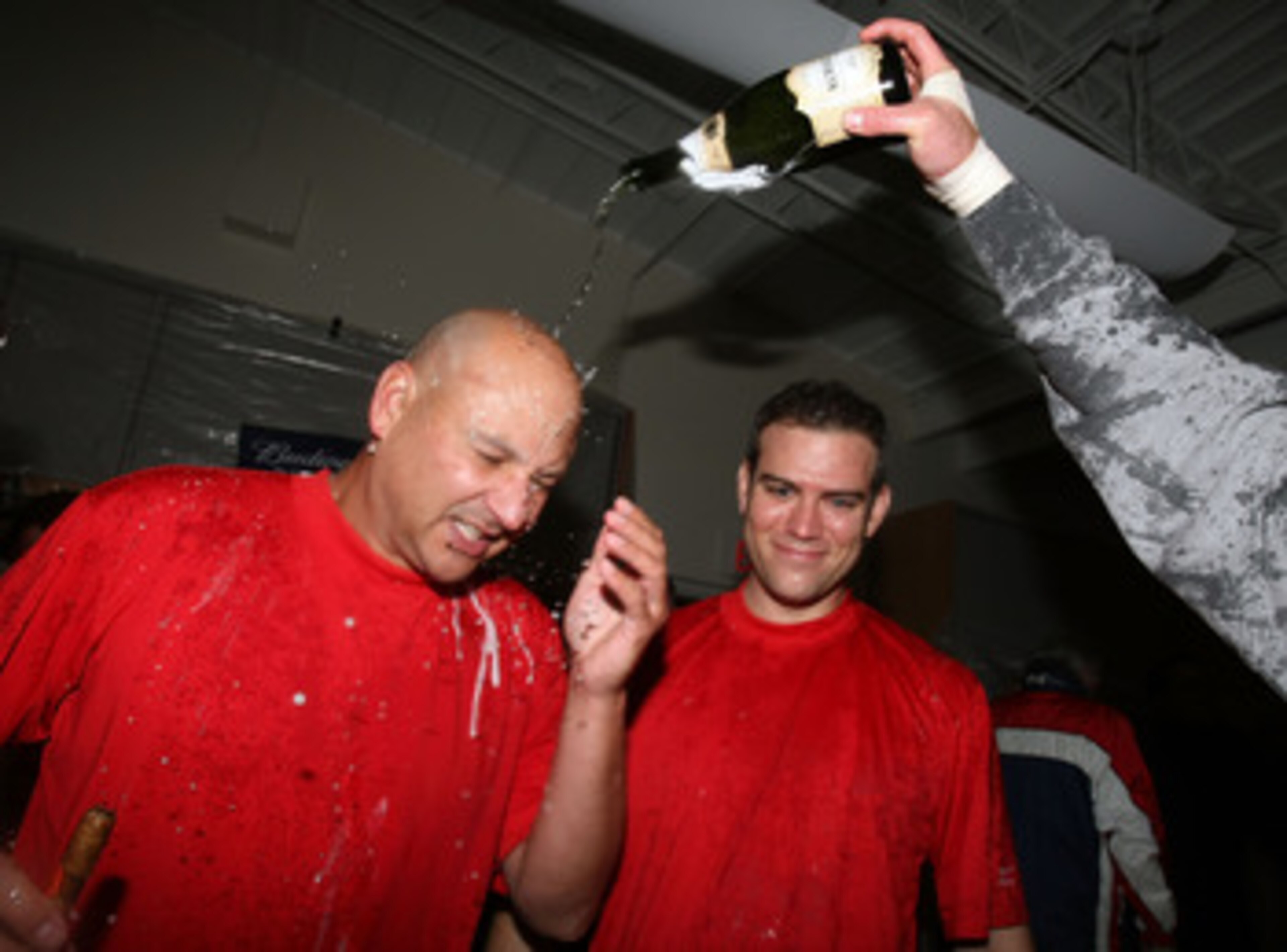 BOSTON - OCTOBER 06:  Manager Terry Francona #47 and Theo Epstein of the Boston Red Sox celebrate in the clubhouse after the Red Sox scored a run in the bottom of the ninth inning to win Game Four of the American League Championship Series on October 6, 2