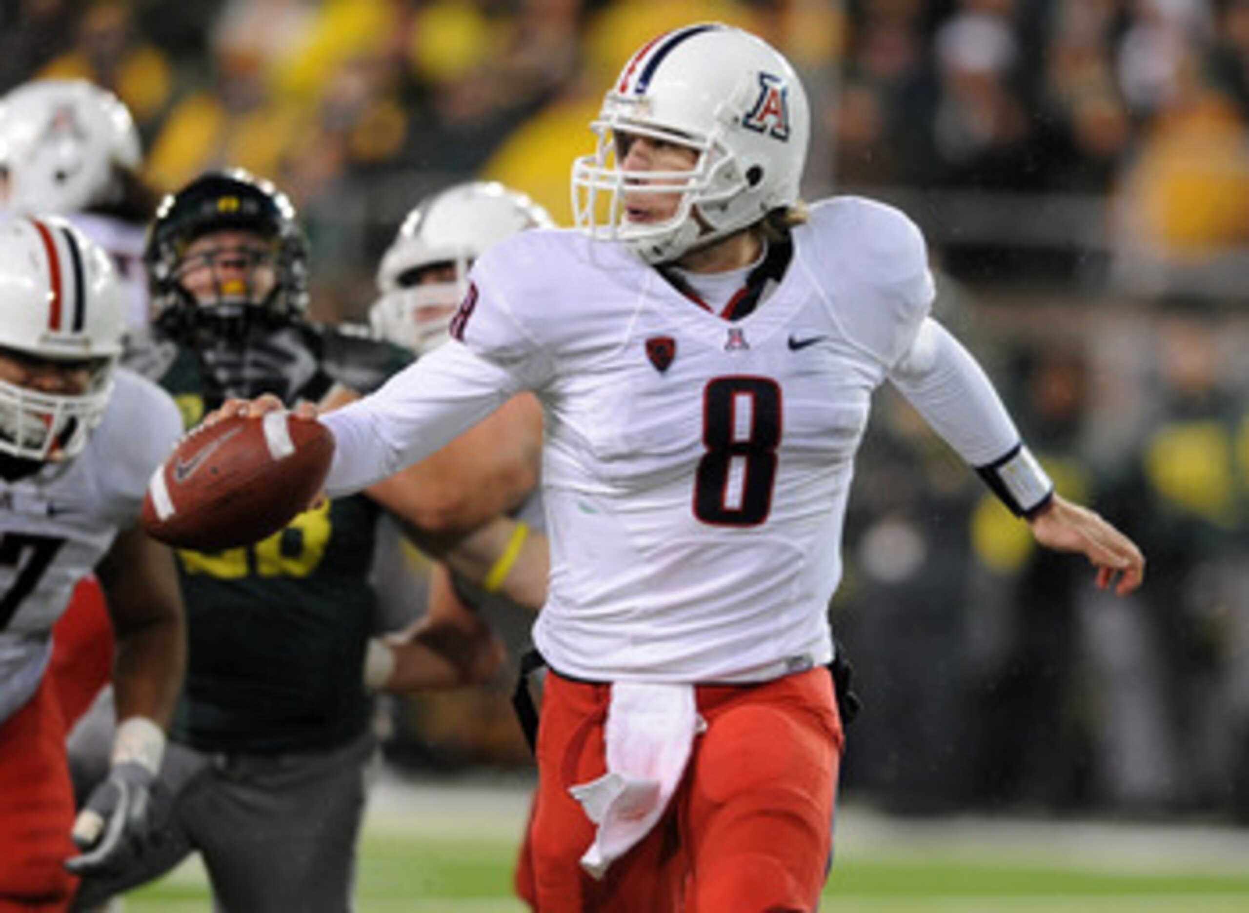 EUGENE, OR - NOVEMBER 26: Quarterback Nick Foles #8 of the Arizona Wildcats looks for someone to flip the ball to in the fourth quarter of the game at against the Oregon Ducks at Autzen Stadium on November 26, 2010 in Eugene, Oregon. The Ducks won the gam