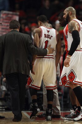 CHICAGO, IL - MAY 02: Derrick Rose #1 of the Chicago Bulls is helped off of the court by trainer Fred Tedeschi and Carlos Boozer #5 after a loss to the Atlanta Hawks in Game One of the Eastern Conference Semifinals in the 2011 NBA Playoffs at the United C