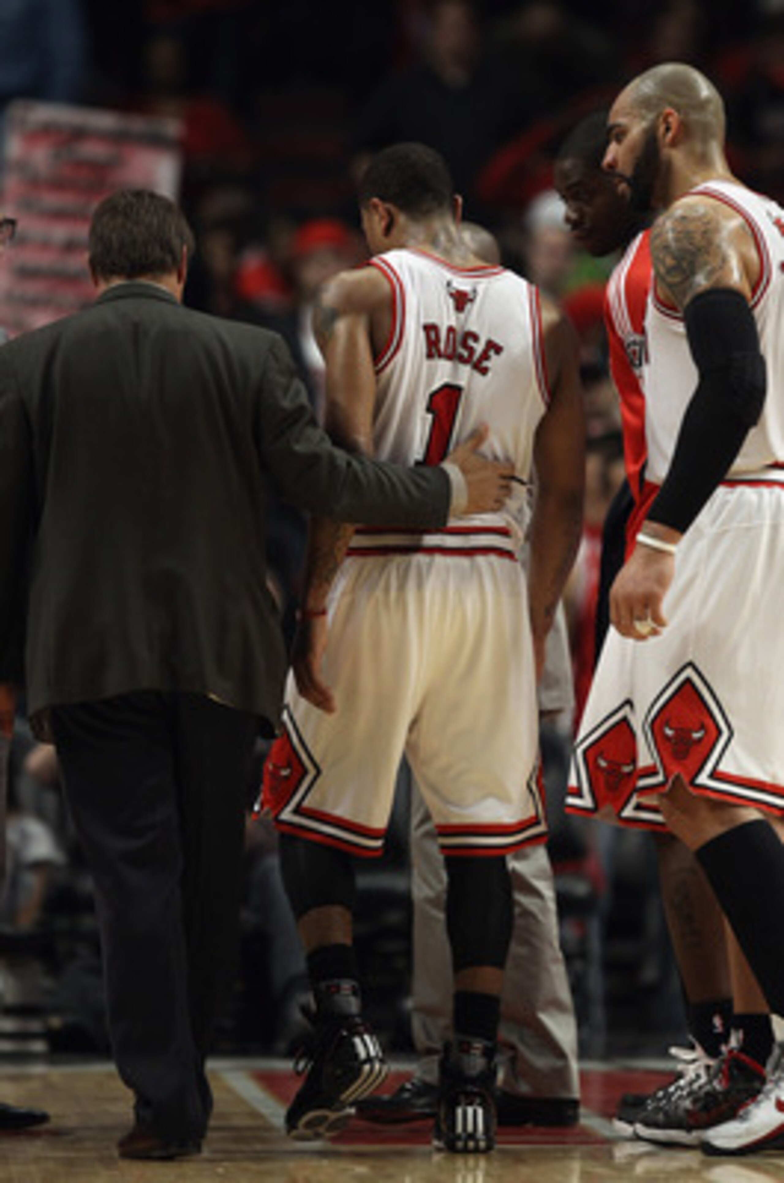 CHICAGO, IL - MAY 02: Derrick Rose #1 of the Chicago Bulls is helped off of the court by trainer Fred Tedeschi and Carlos Boozer #5 after a loss to the Atlanta Hawks in Game One of the Eastern Conference Semifinals in the 2011 NBA Playoffs at the United C