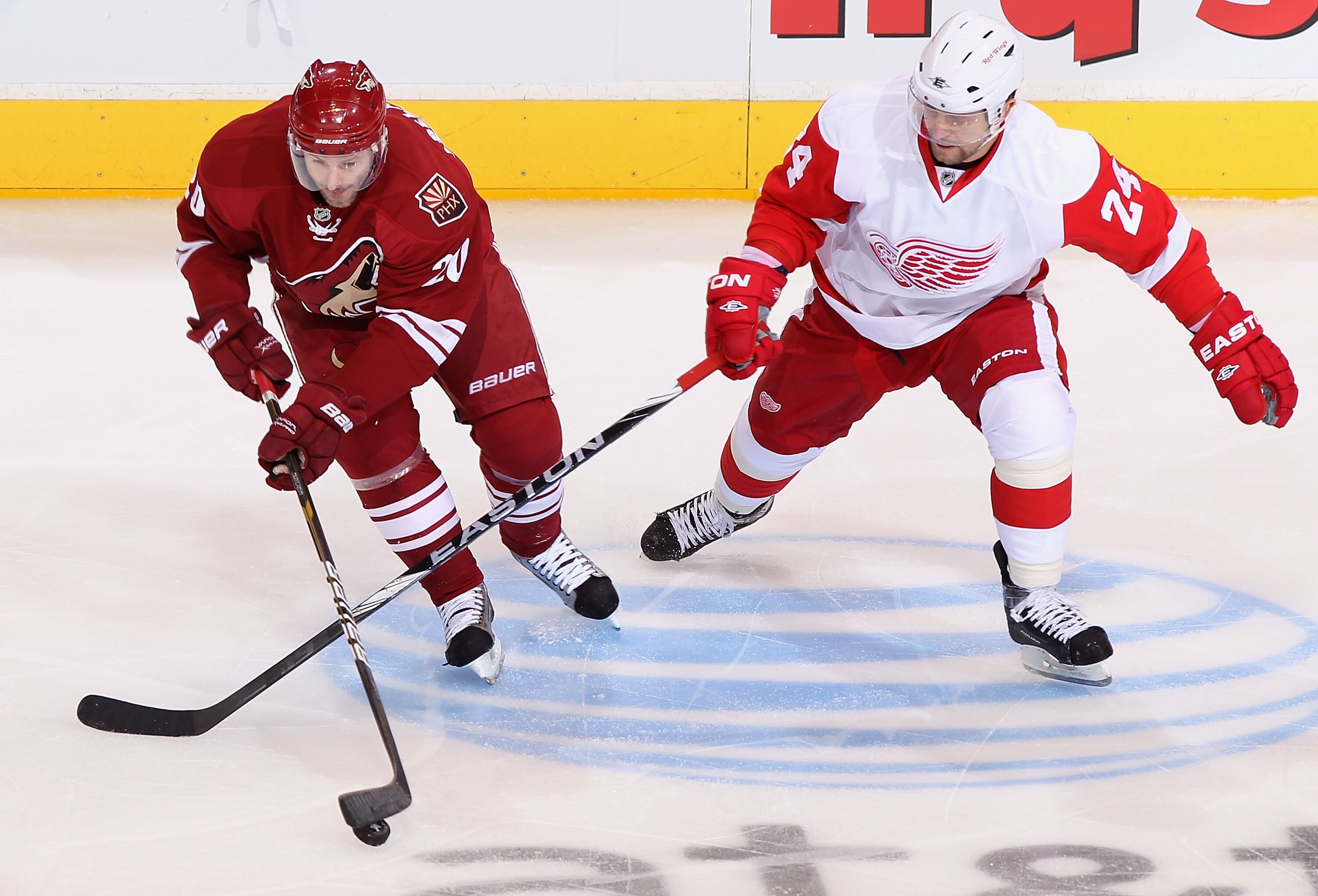 GLENDALE, AZ - APRIL 20:  Eric Belanger #20 of the Phoenix Coyotes skates with the puck under pressure from Ruslan Salei #24 of the Detroit Red Wings in Game Four of the Western Conference Quarterfinals during the 2011 NHL Stanley Cup Playoffs at Jobing.c