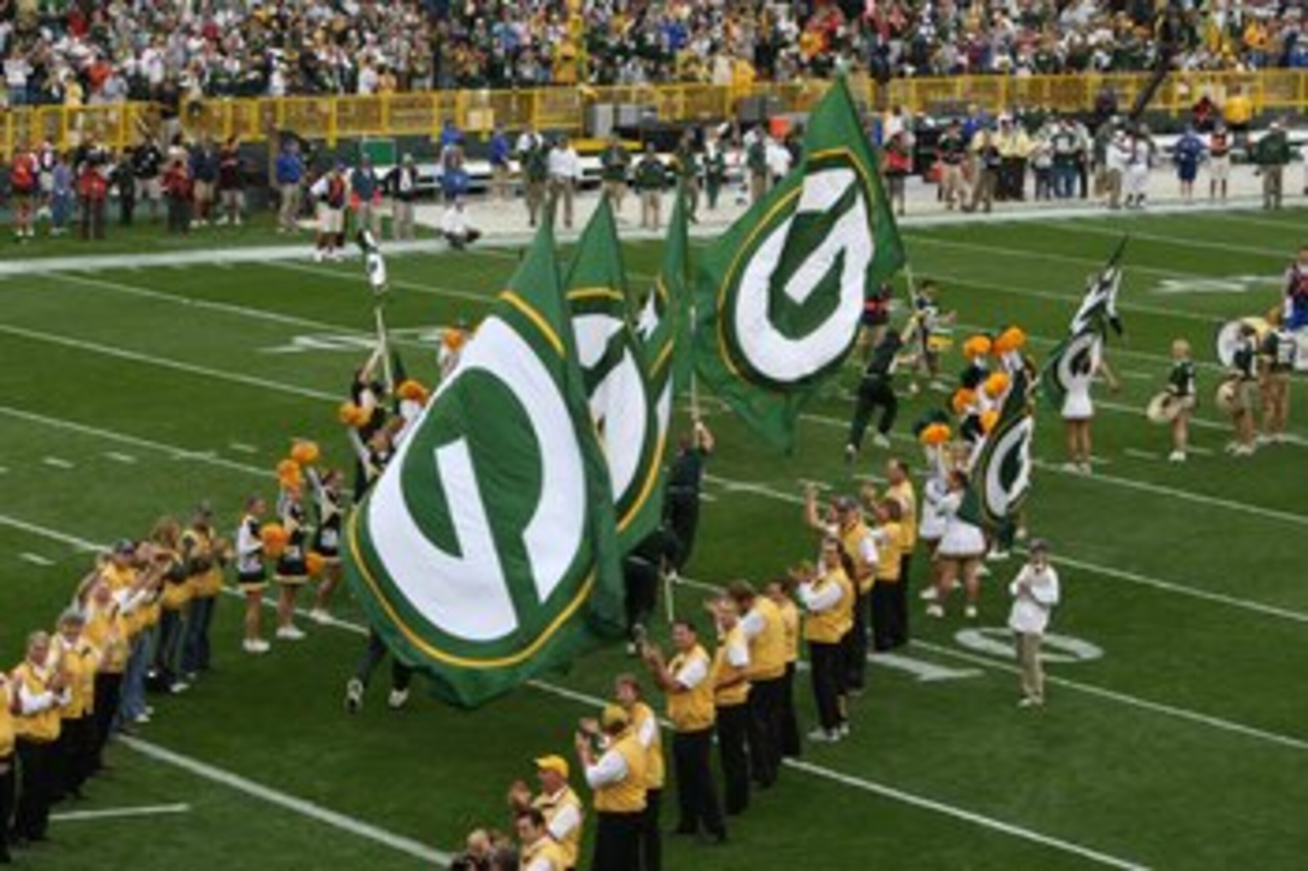 GREEN BAY, WI - SEPTEMBER 09: Cheerleaders carry flags of the Green Bay Packers as they run onto the field before a game against the Philadelphia Eagles on September 9, 2007 at Lambeau Field in Green Bay, Wisconsin. The Packers defeated the Eagles 16-13.