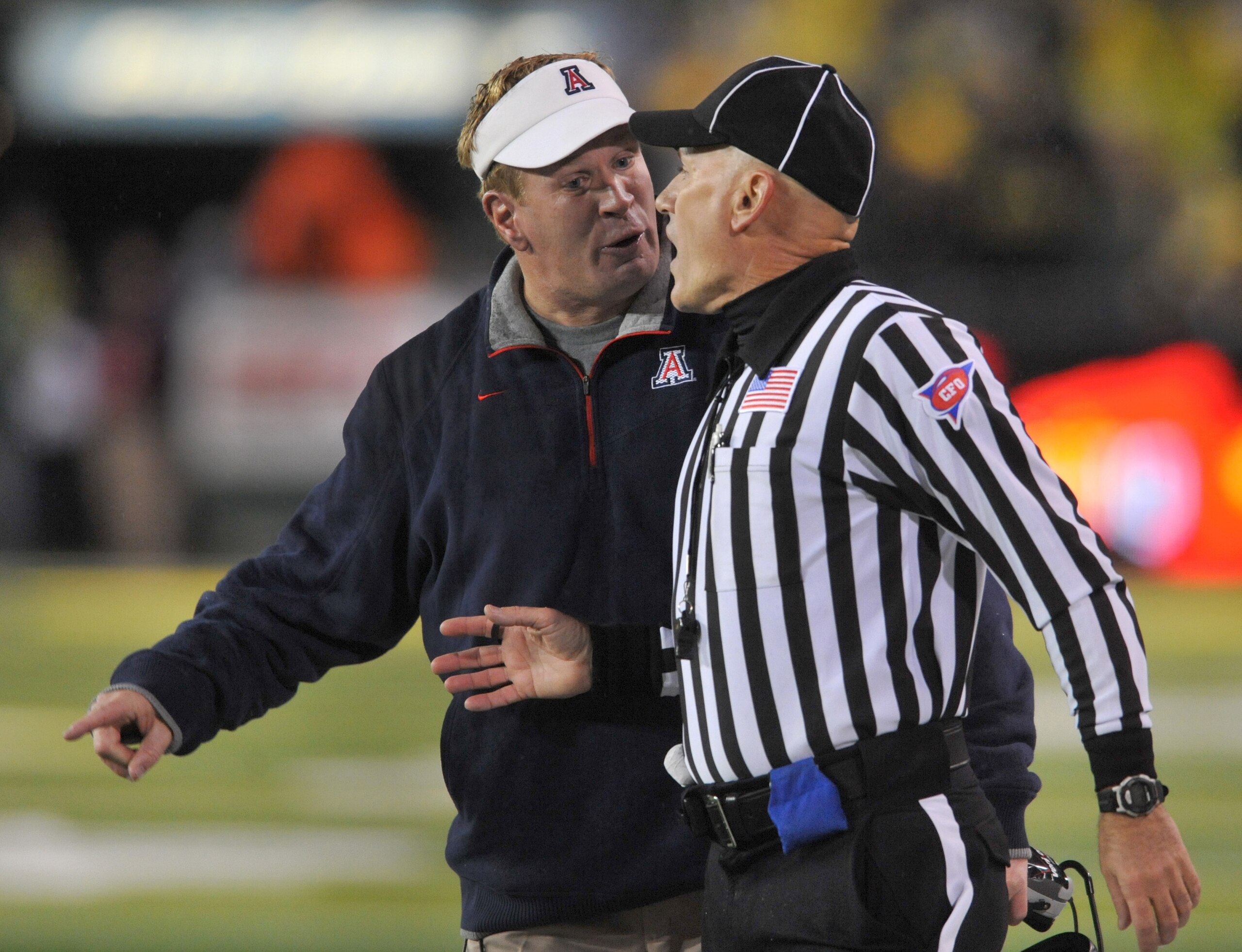 EUGENE, OR - NOVEMBER 26: Head coach Mike Stoops of the Arizona Wildcats has some words with head linesman Cappy Anderson in the second quarter of the game against the Oregon Ducks at Autzen Stadium on November 26, 2010 in Eugene, Oregon.The Ducks won the