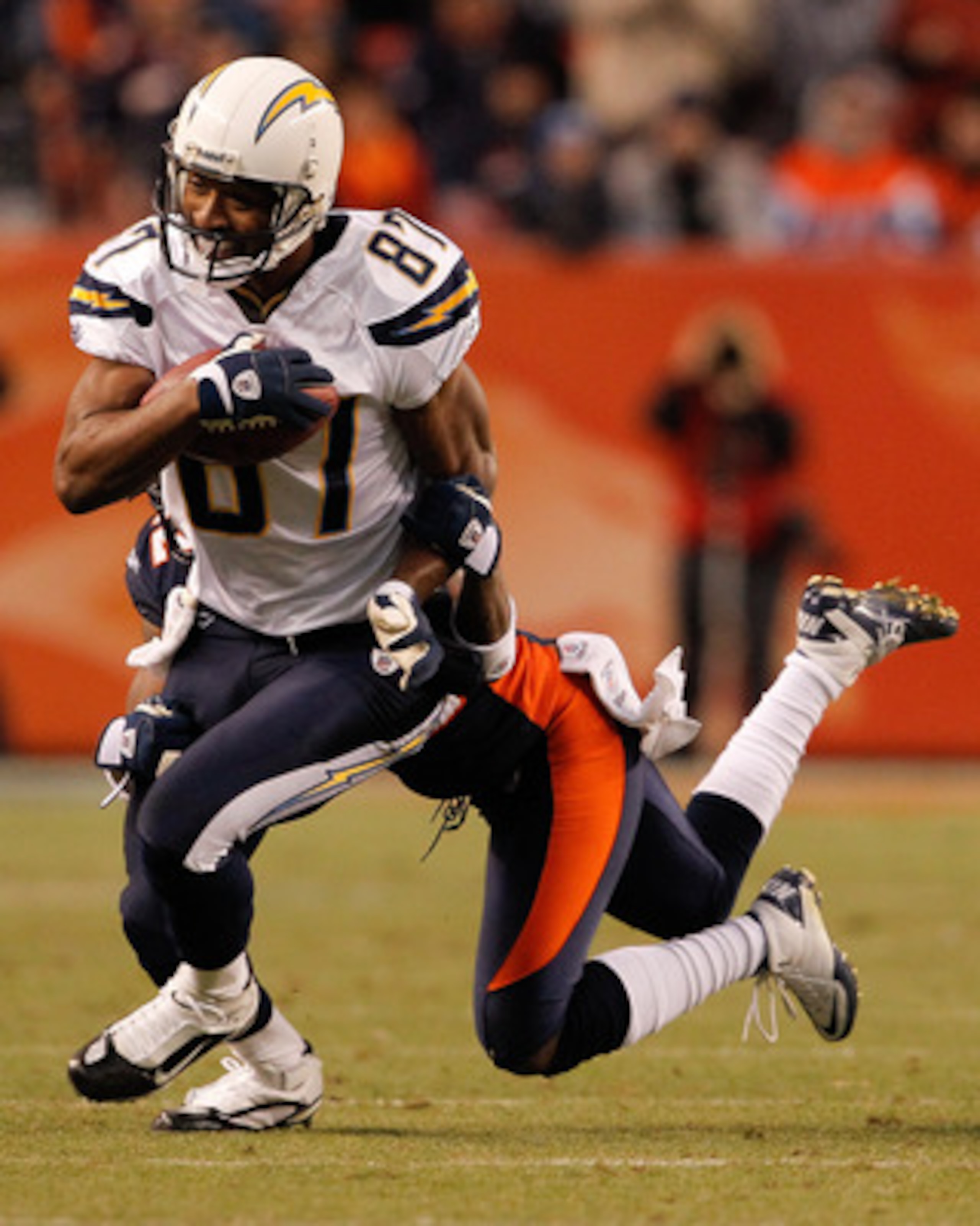 DENVER, CO - JANUARY 2:  Wide receiver Kelley Washington #87 of the San Diego Chargers is tackled after a reception by cornerback Syd'Quan Thompson #22 of the Denver Broncos during the fourth quarter at INVESCO Field at Mile High on January 2, 2011 in Den