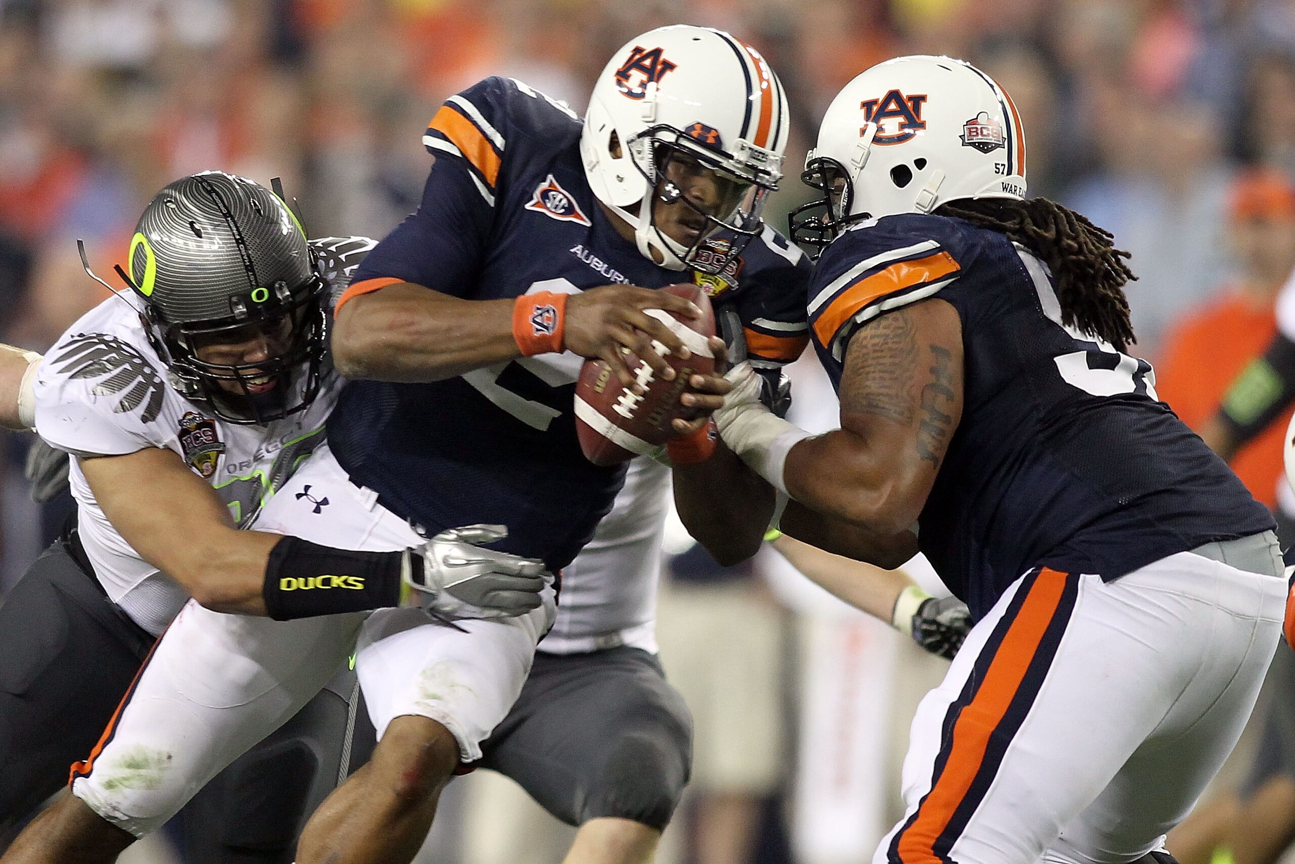 GLENDALE, AZ - JANUARY 10:  Quarterback Cameron Newton #2 of the Auburn Tigers is sacked by Zac Clark #99 of the Oregon Ducks in the first quarter during the Tostitos BCS National Championship Game at University of Phoenix Stadium on January 10, 2011 in G