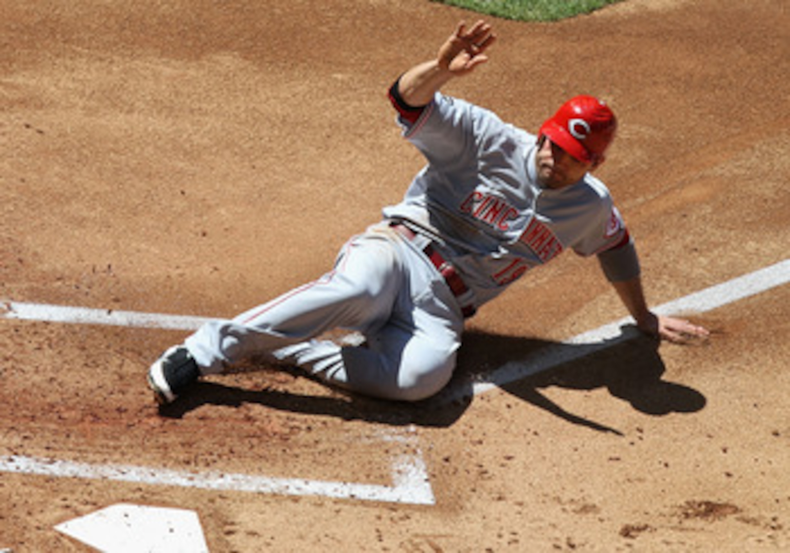 PHOENIX, AZ - APRIL 10:  Joey Votto #19 of the Cincinnati Reds slides in to score a first inning run against the Arizona Diamondbacks during the Major League Baseball game at Chase Field on April 10, 2011 in Phoenix, Arizona.  (Photo by Christian Petersen
