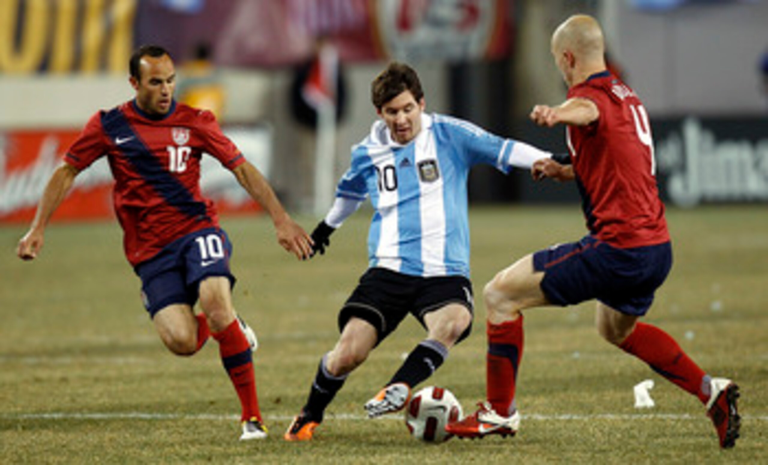 EAST RUTHERFORD, NJ - MARCH 26:  Lionel Messi #10 of Argentina dribbles between Landon Donovan #10 and Michael Bradley #4 of the United States during the first half of a friendly match at New Meadowlands Stadium on March 26, 2011 in East Rutherford, New J