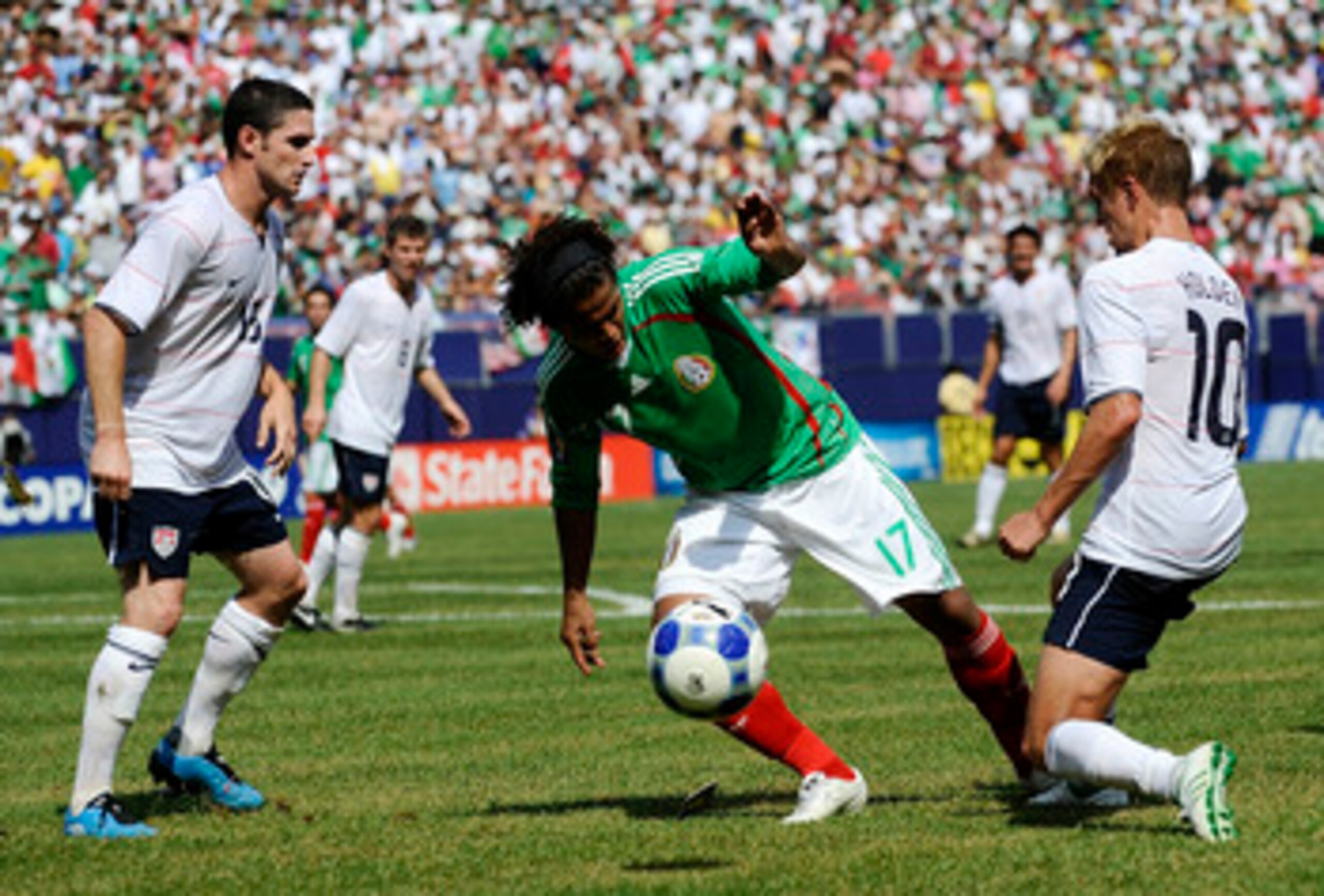 EAST RUTHERFORD, NJ - JULY 26:  Giovani Dos Santos #1 dribbles between Sam Cronin #15 and Stuart Holden #10 of the United States in the CONCACAF Gold Cup Championship match at Giants Stadium on July 26, 2009 in East Rutherford, New Jersey.  (Photo by Jeff