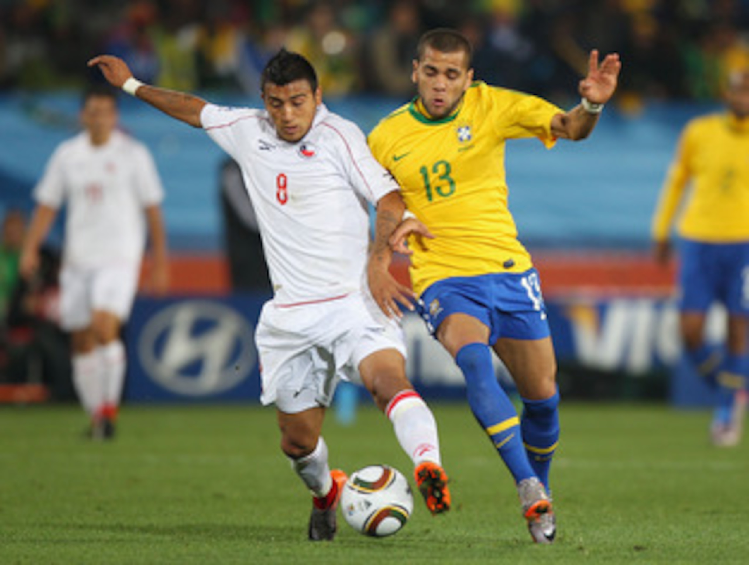 JOHANNESBURG, SOUTH AFRICA - JUNE 28:  Arturo Vidal of Chile and Dani Alves of Brazil challenge for the ball during the 2010 FIFA World Cup South Africa Round of Sixteen match between Brazil and Chile at Ellis Park Stadium on June 28, 2010 in Johannesburg