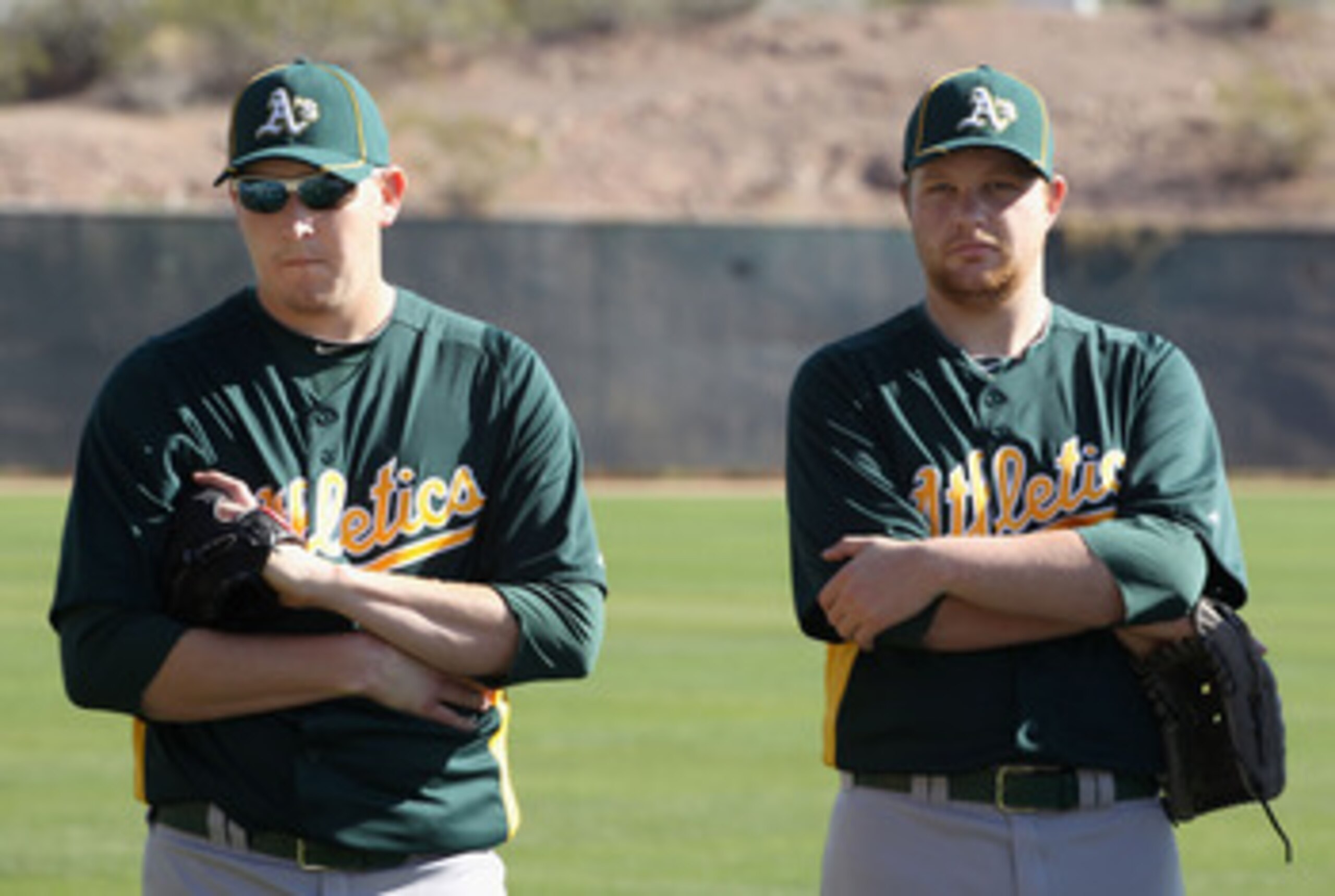 PHOENIX, AZ - FEBRUARY 16:  (L-R) Pitchers Trevor Cahill #53 and Brett Anderson #49 of the Oakland Athletics warm up during a MLB spring training practice at Phoenix Municipal Stadium on February 16, 2011 in Phoenix, Arizona.  (Photo by Christian Petersen