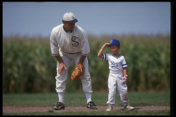 DYERSVILLE, IA - AUGUST 25: A 'ghost player' recreating the role of Chicago White Sox legend Shoeless Joe Jackson plays ball with a young tourist at the baseball field created for the motion picture 'Field of Dreams' on August 25, 1991 in Dyersville, Iowa
