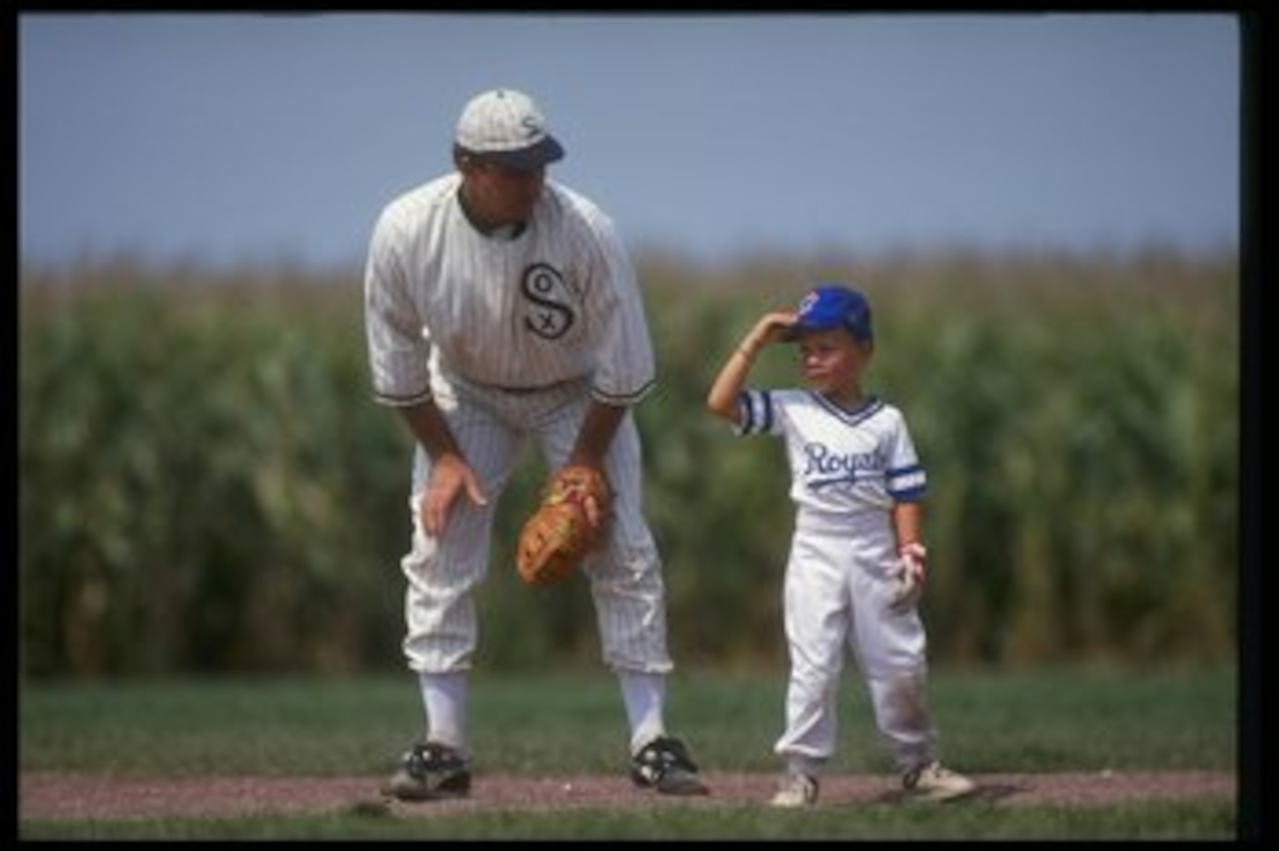 DYERSVILLE, IA - AUGUST 25: A 'ghost player' recreating the role of Chicago White Sox legend Shoeless Joe Jackson plays ball with a young tourist at the baseball field created for the motion picture 'Field of Dreams' on August 25, 1991 in Dyersville, Iowa