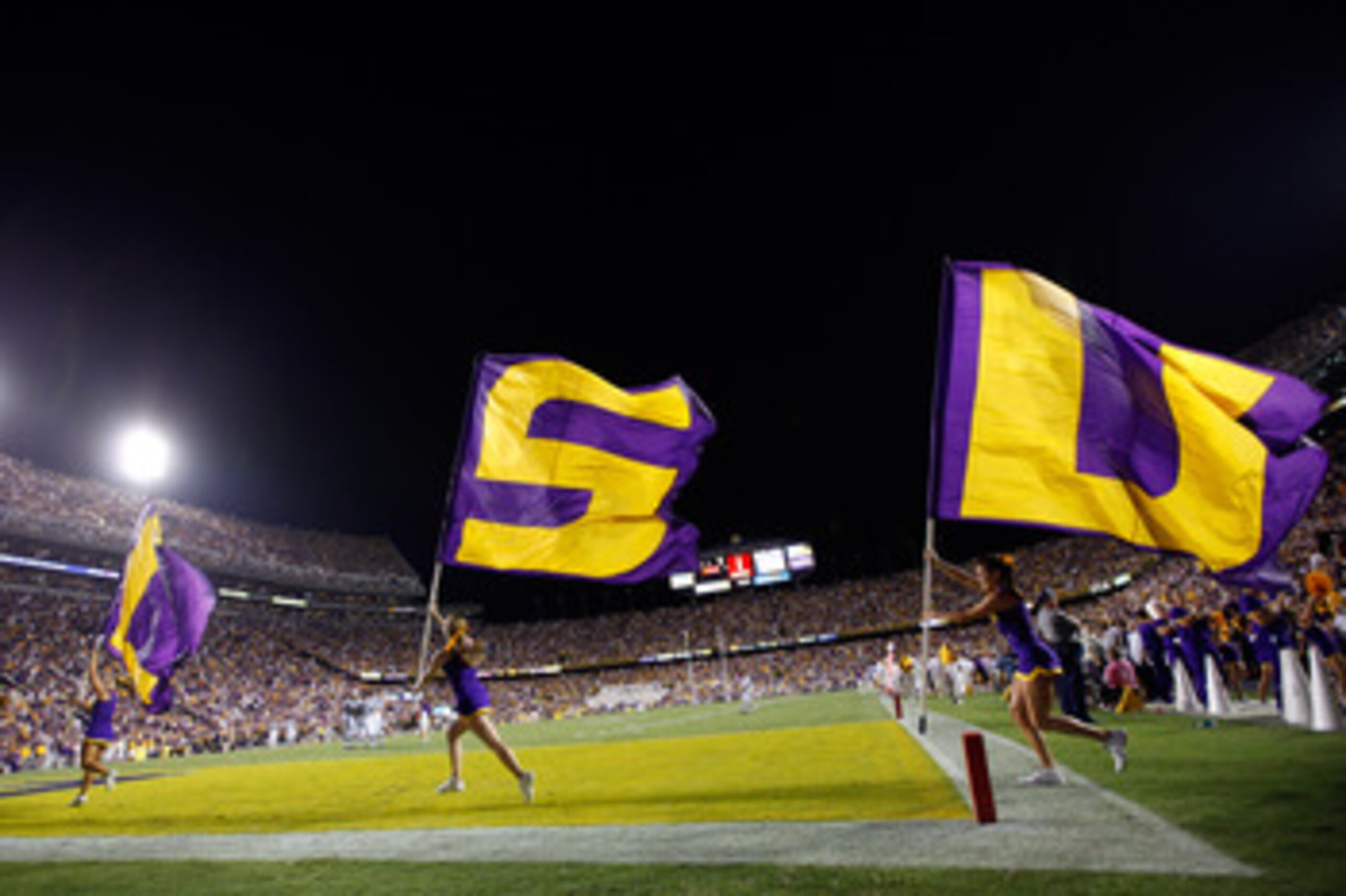BATON ROUGE, LA - SEPTEMBER 25:  Cheerleaders run with flags after a touchdown during the game between the Louisiana State Univeristy Tigers and the West Virginia Mountaineers at Tiger Stadium on September 25, 2010 in Baton Rouge, Louisiana.   The Tigers 