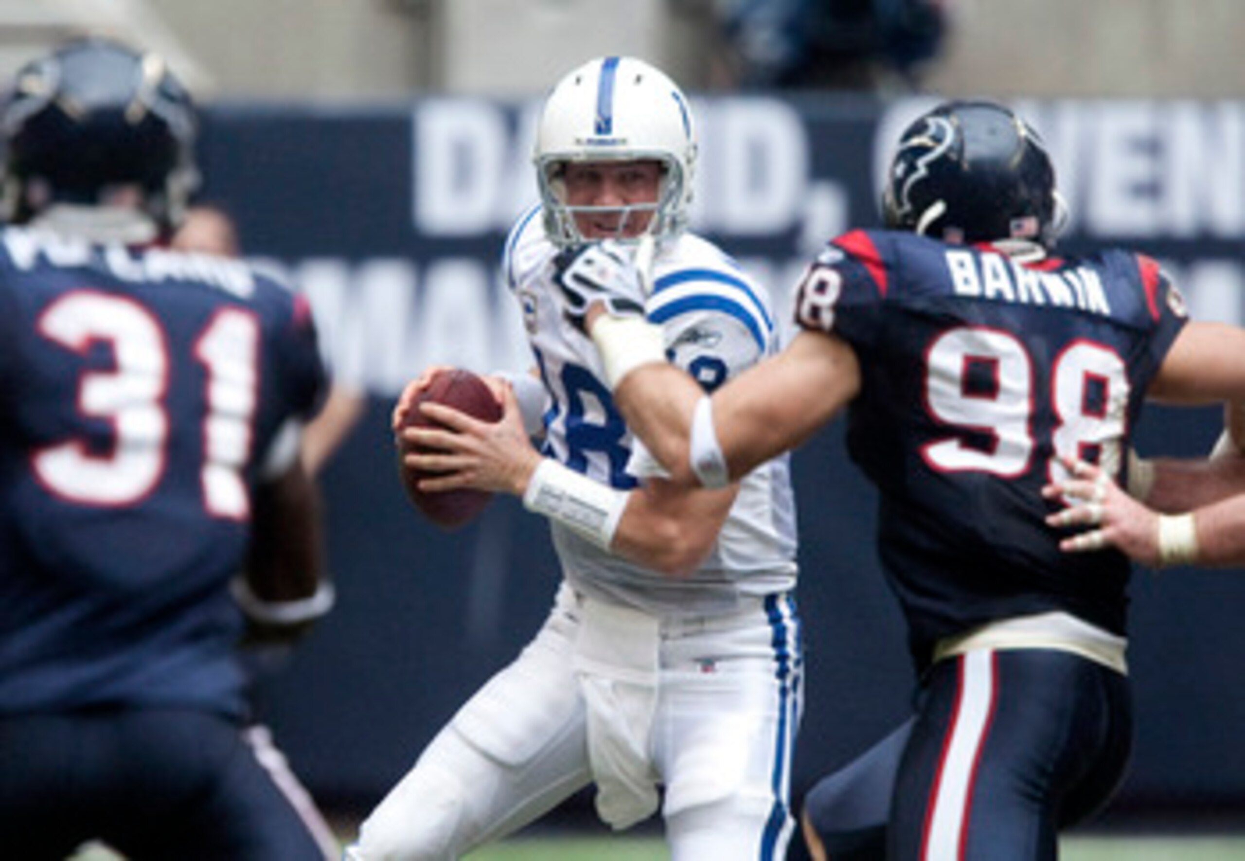 HOUSTON - NOVEMBER 29:  Quarterback Peyton Manning #18 of the Indianapolis Colts looks for a receiver as he is pressured by defensive end Connor Barwin #98 of the Houston Texans in the third quarter against the Houston Texans at Reliant Stadium on Novembe