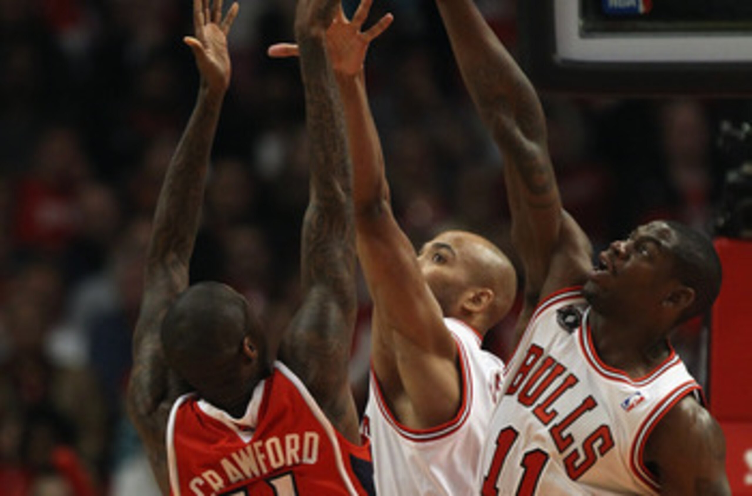CHICAGO, IL - MAY 04: Jamal Crawford #11 of the Atlanta Hawks puts up a shot under pressure from Ronnie Brewer #11 and Taj Gibson #22 of the Chicago Bulls in Game Two of the Eastern Conference Semifinals in the 2011 NBA Playoffs at the United Center on Ma
