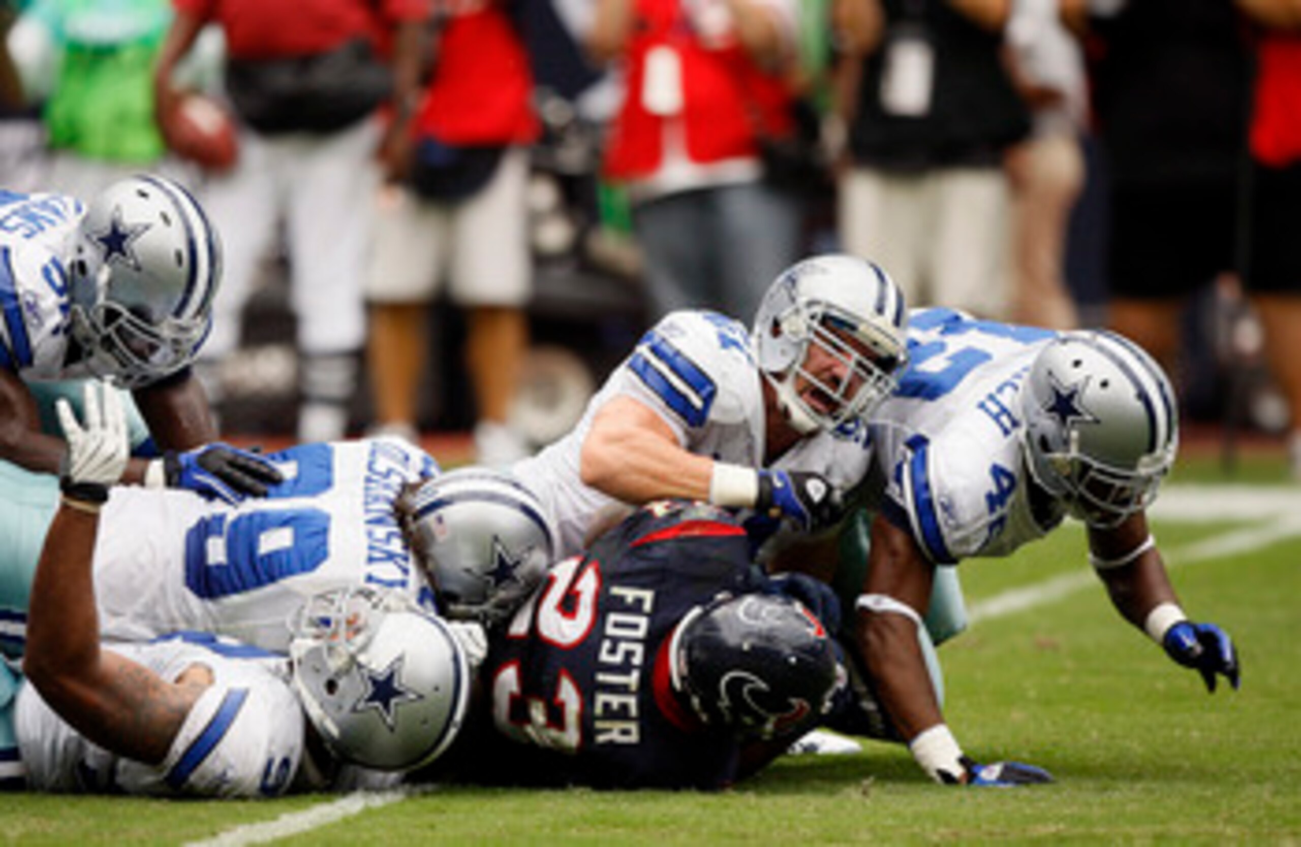 HOUSTON - SEPTEMBER 26:  Running back Arian Foster #23 of the Houston Texans is stopped by defensive end Igor Olshansky #99, line backer Keith Brookings #51 and safety Barry Church #42 of the Dallas Cowboys at Reliant Stadium on September 26, 2010 in Hous