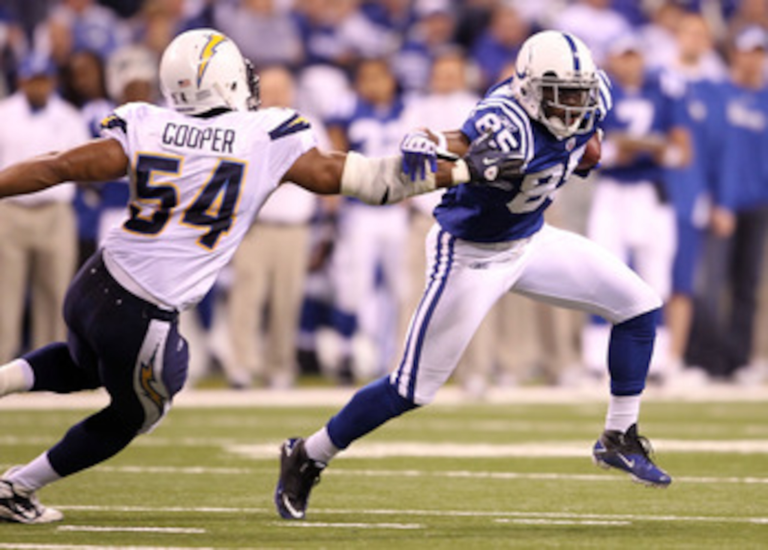 INDIANAPOLIS - NOVEMBER 28:  Pierre Garcon #85 of the Indianapolis Colts runs with the ball while defended by Stephen Cooper #54 of the San Diego Chargers during the NFL game at Lucas Oil Stadium on November 28, 2010 in Indianapolis, Indiana.  (Photo by A