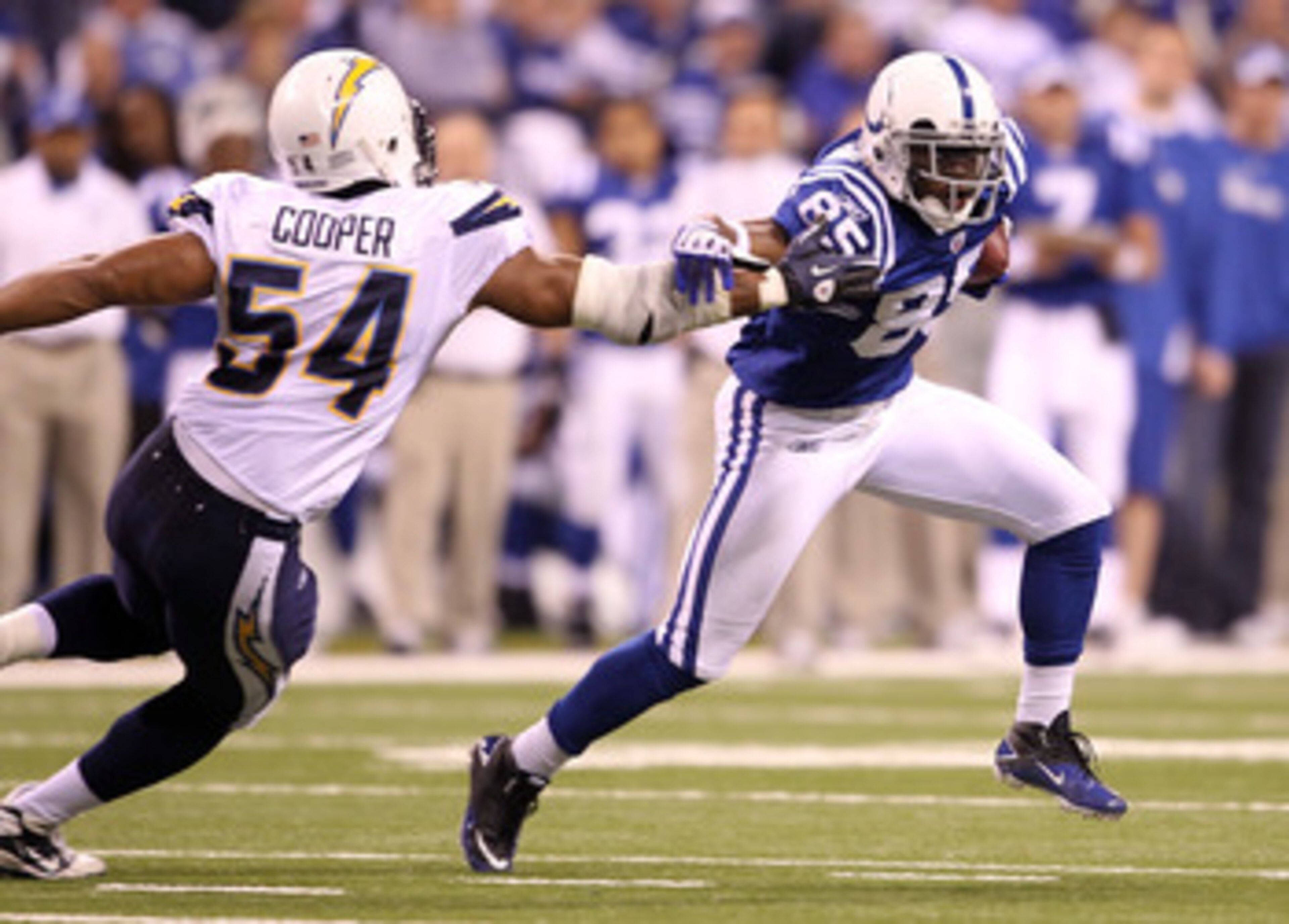 INDIANAPOLIS - NOVEMBER 28:  Pierre Garcon #85 of the Indianapolis Colts runs with the ball while defended by Stephen Cooper #54 of the San Diego Chargers during the NFL game at Lucas Oil Stadium on November 28, 2010 in Indianapolis, Indiana.  (Photo by A